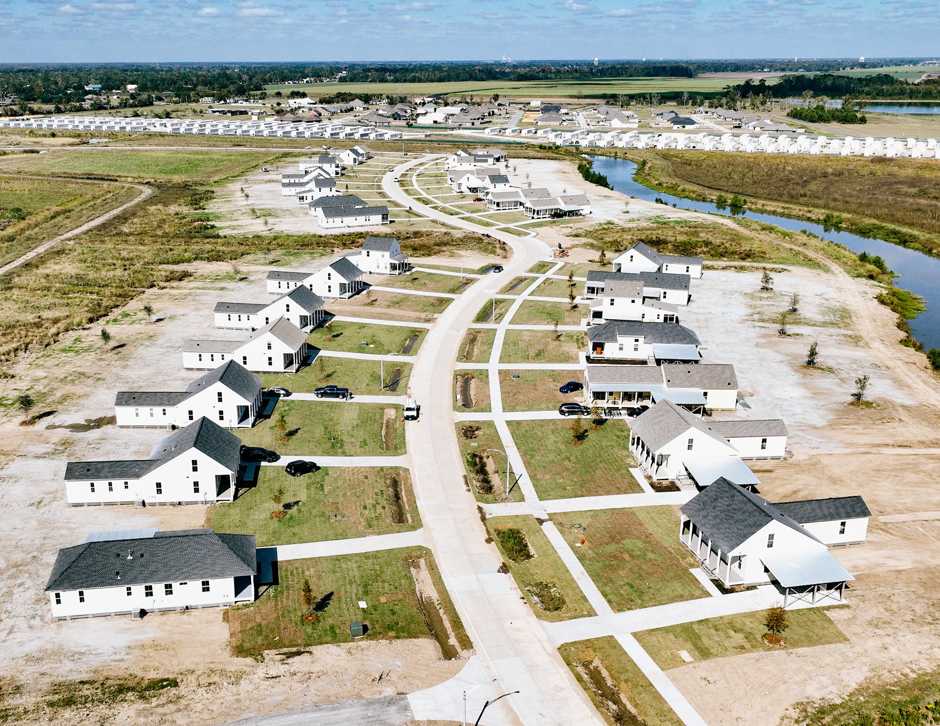 In 2022, residents of Isle de Jean-Charles relocated 65 km north to Gray, where they received free housing in a development on an old sugar plantation, consisting of 37 houses. However, they now face financial strain as they must pay taxes and insurance, which can be particularly challenging for those on social benefits. Eligibility for this housing was limited to residents present during Hurricane Isaac in 2012 or those who settled afterward. Others displaced by previous disasters must cover the costs of constructing their homes. Gray, Louisiana, United States.
