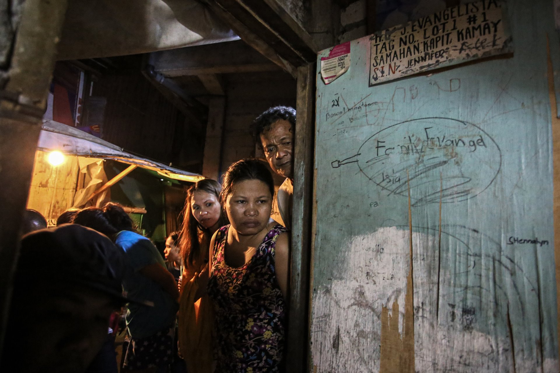 <p>Neighbors survey the crime scene hours after masked men massacred Manuel Evangelista, Edmar Velarde, Paulo Tuboro, Jennifer Discargar, and Catalino Algueles, in Mandaluyong, the Philippines.</p>
