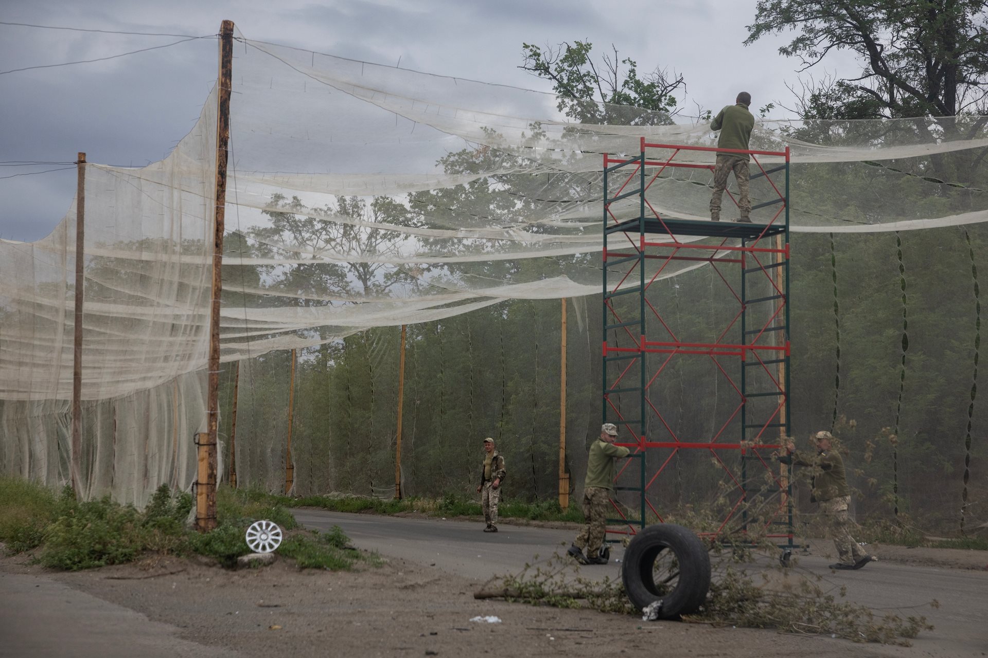 Ukrainian soldiers erect security nets over a highway on the edge of the severely damaged and mostly-abandoned town of Kostyantynivka in Ukraine, to protect the area against Russian FPV drones.