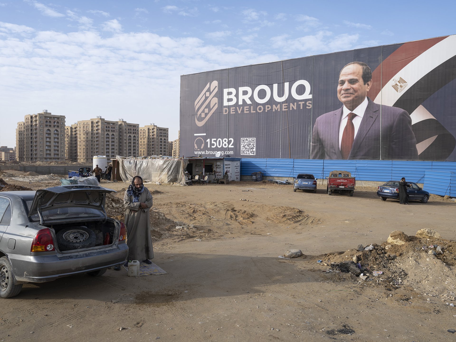 A man prays near a billboard depicting Egyptian president Abdel Fattah el-Sissi, in Egypt&#39;s New Administrative Capital, under construction near Cairo.