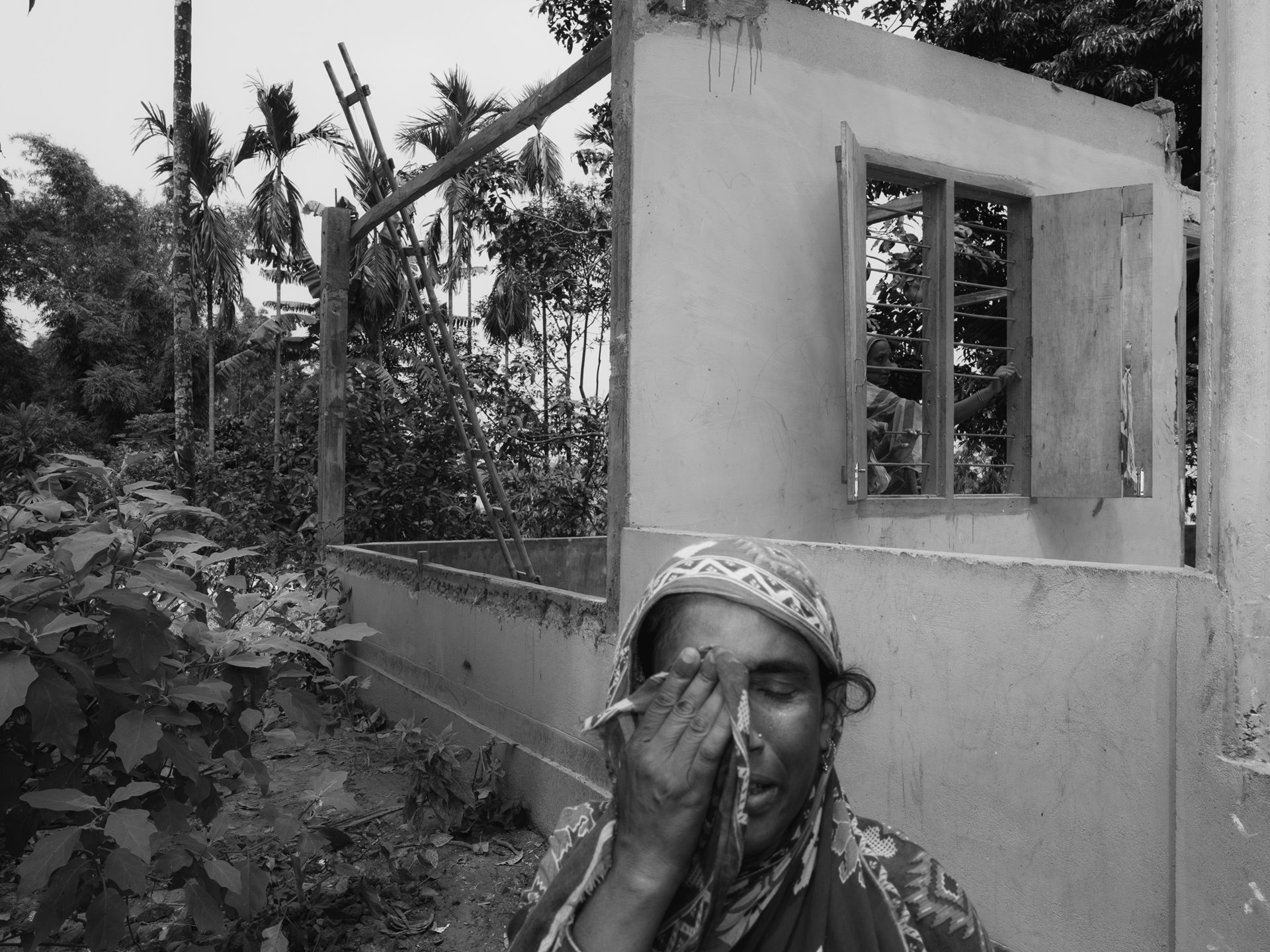 In Kharbali village, a Bengali Muslim woman breaks down in tears while dismantling her family&#39;s home in Kharbali, on the edge of the Beki River. Annual flash floods, exacerbated by dam releases from Bhutan, force their relocation. This cyclical displacement, made worse by climate change, takes a toll on mental health, with studies linking frequent evacuation and displacement to increased risk of post-traumatic stress disorder, anxiety, and depression, underscoring the mental health impacts of climate-induced migration in vulnerable communities. Kharbali West, Barpeta, Lower Assam, India.