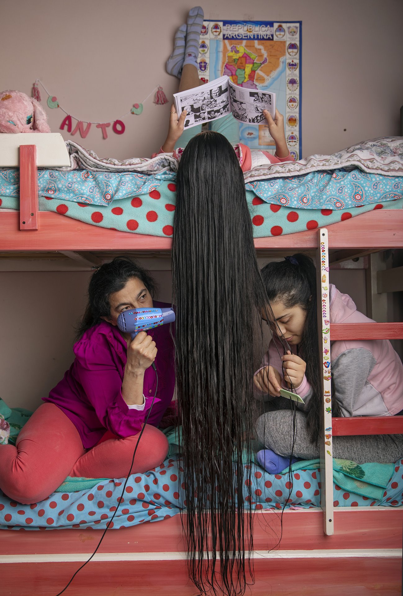 <p>Antonella&rsquo;s mother Felicitas and her sister Carolina dry, comb and rub her hair with rosemary oil, at home in Buenos Aires, Argentina. Numerous academic studies highlight the importance of strong parental support in creating positive attitudes towards education among children studying at home.</p>
