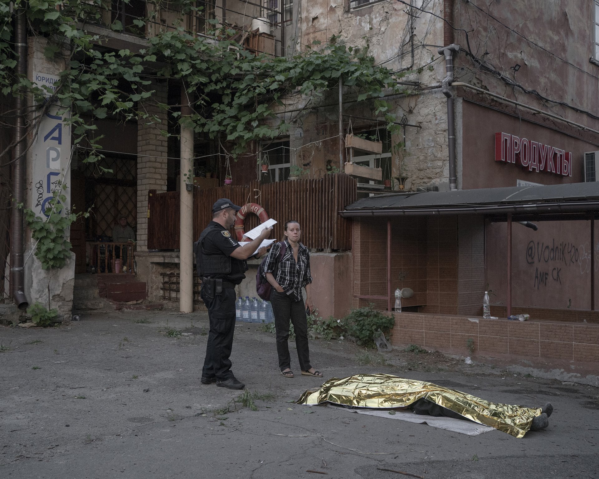 A woman mourns the death of her father from a suspected heart attack in his summerhouse, in Kherson, Ukraine.