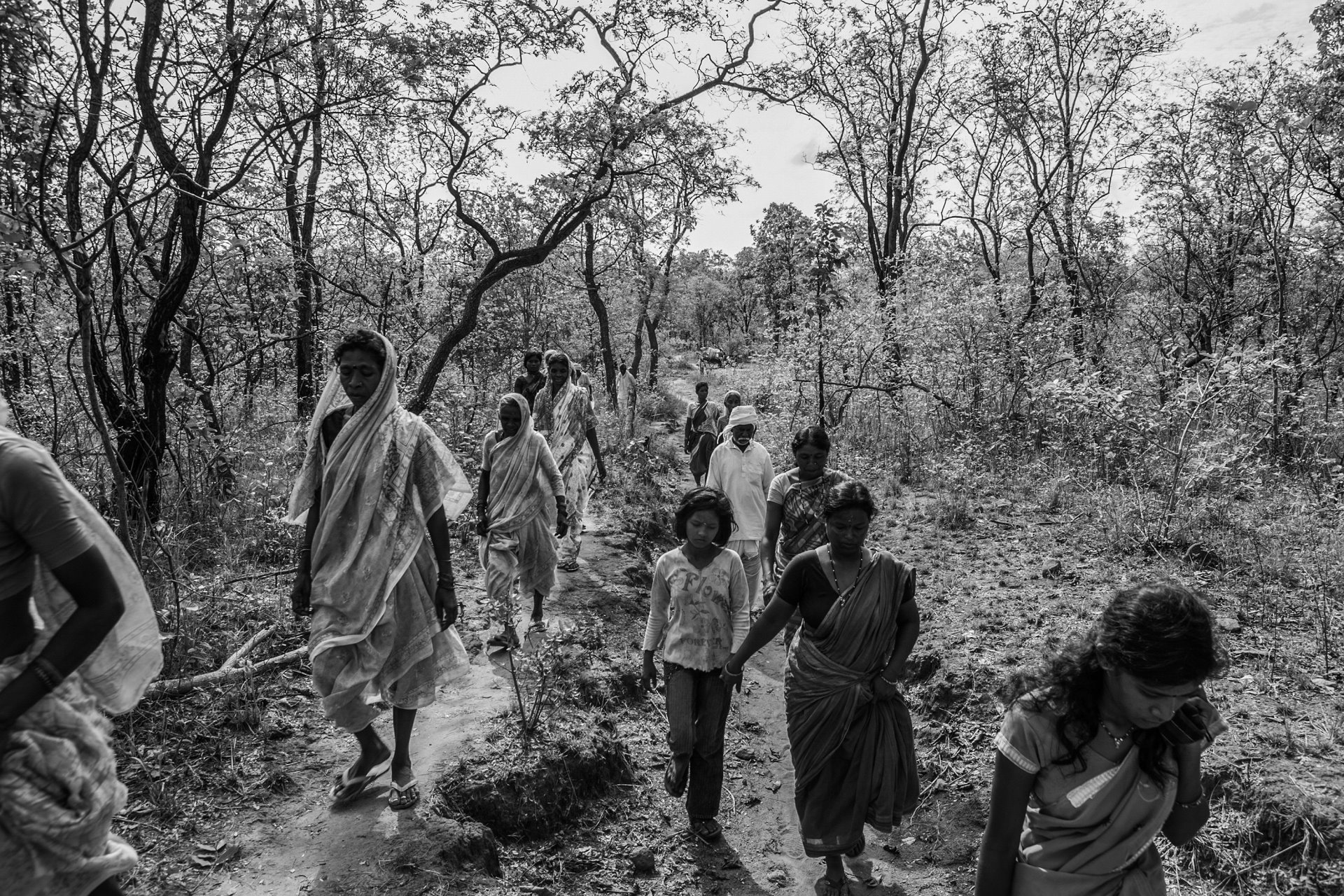 People walk through the forest zone in the Tadoba Andhari Tiger Reserve, near the village of Navegaon, in Maharashtra, India, to attend a funeral.