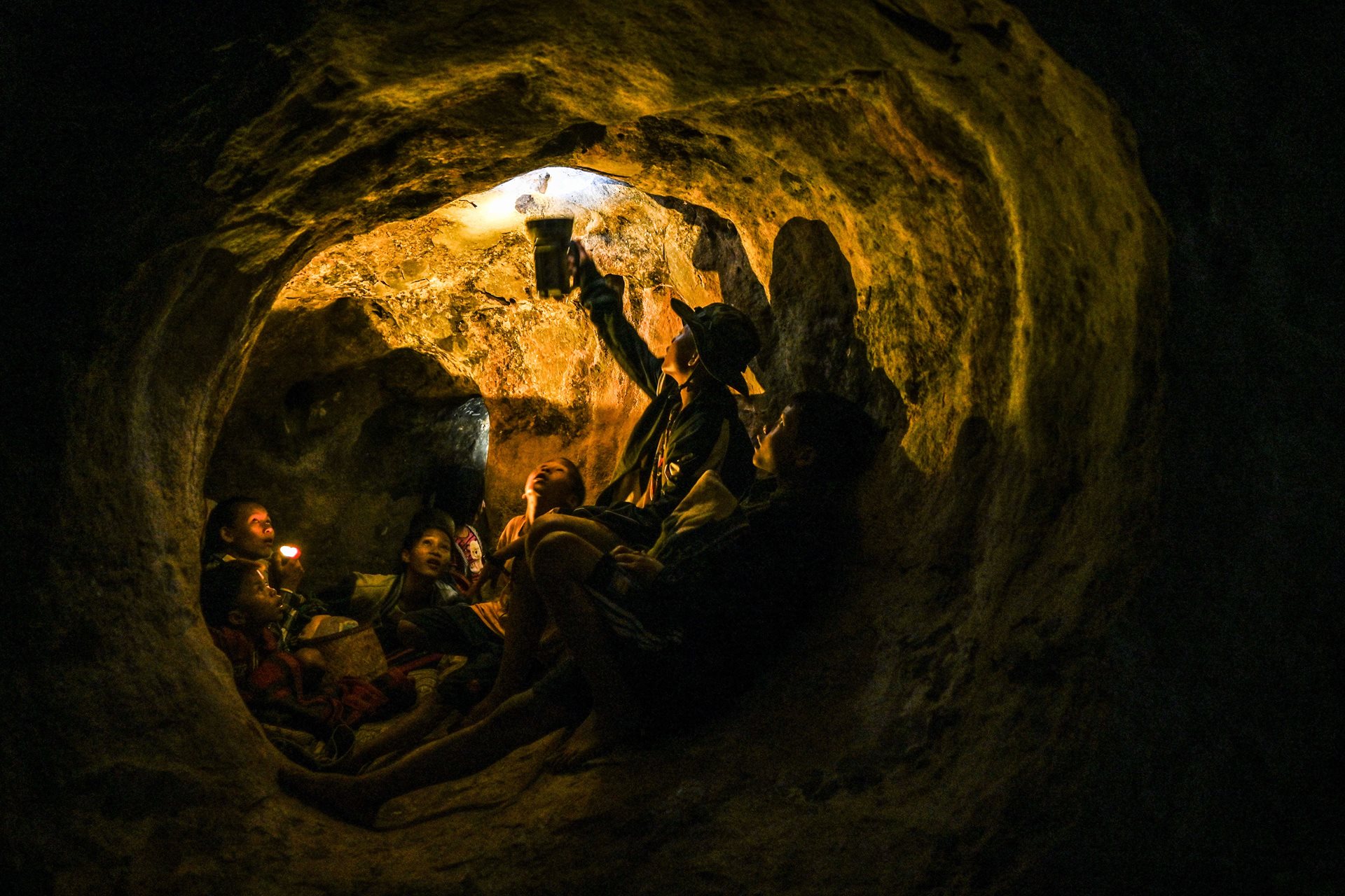 Civilians sheltering in a cave shine light onto a spider, in Demoso, Kayah (Karenni) State, Myanmar. Following junta airstrikes night and day that week, people didn&#39;t dare stay at home and chose to sleep in caves. According to a United Nations report, some 5,000 civilians have been killed since the 2021 coup.