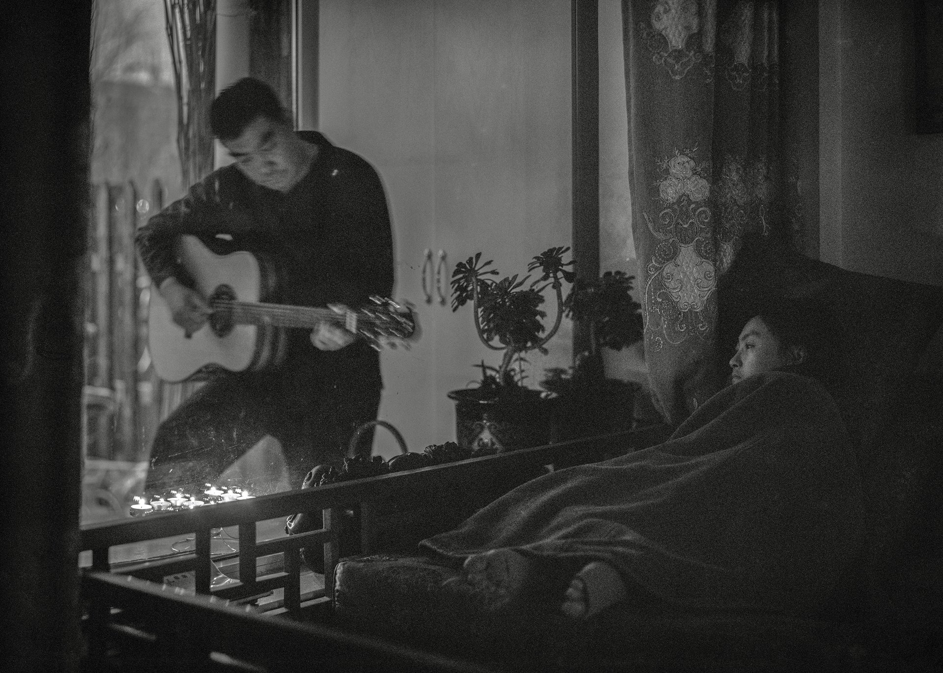 Jiuer&#39;s husband plays the guitar, as he does every day after dinner. This has been a family habit for more than a decade, and it is the time of day Jiuer enjoys the most. Liaoning, China.