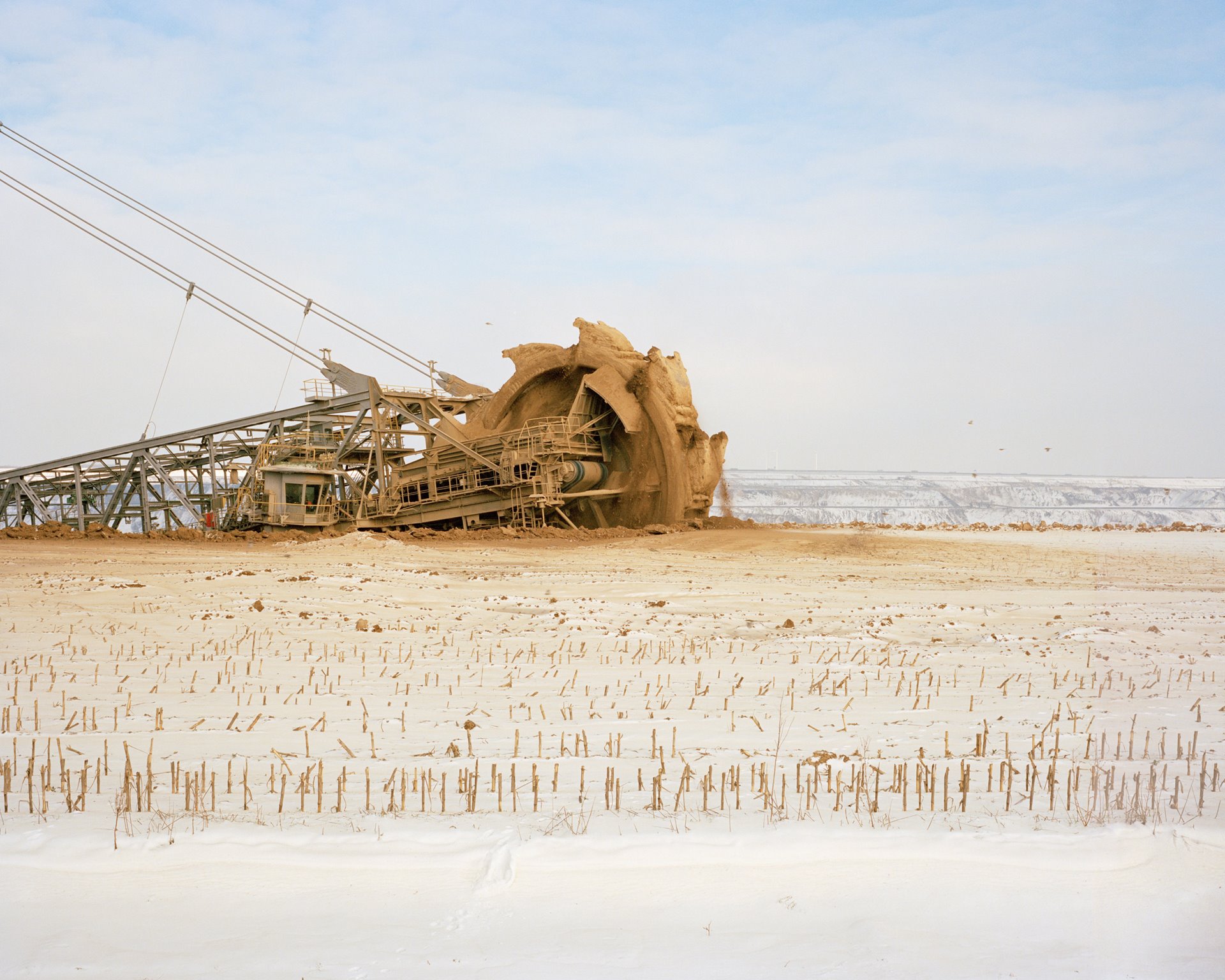 A bucket-wheel excavator digs through a field where corn used to be grown, near the village of Lützerath, in Germany. The machine is enlarging the Garzweiler II opencast mine, which stretches over more than five kilometers. The loess soils in the region are among the most fertile in Germany.