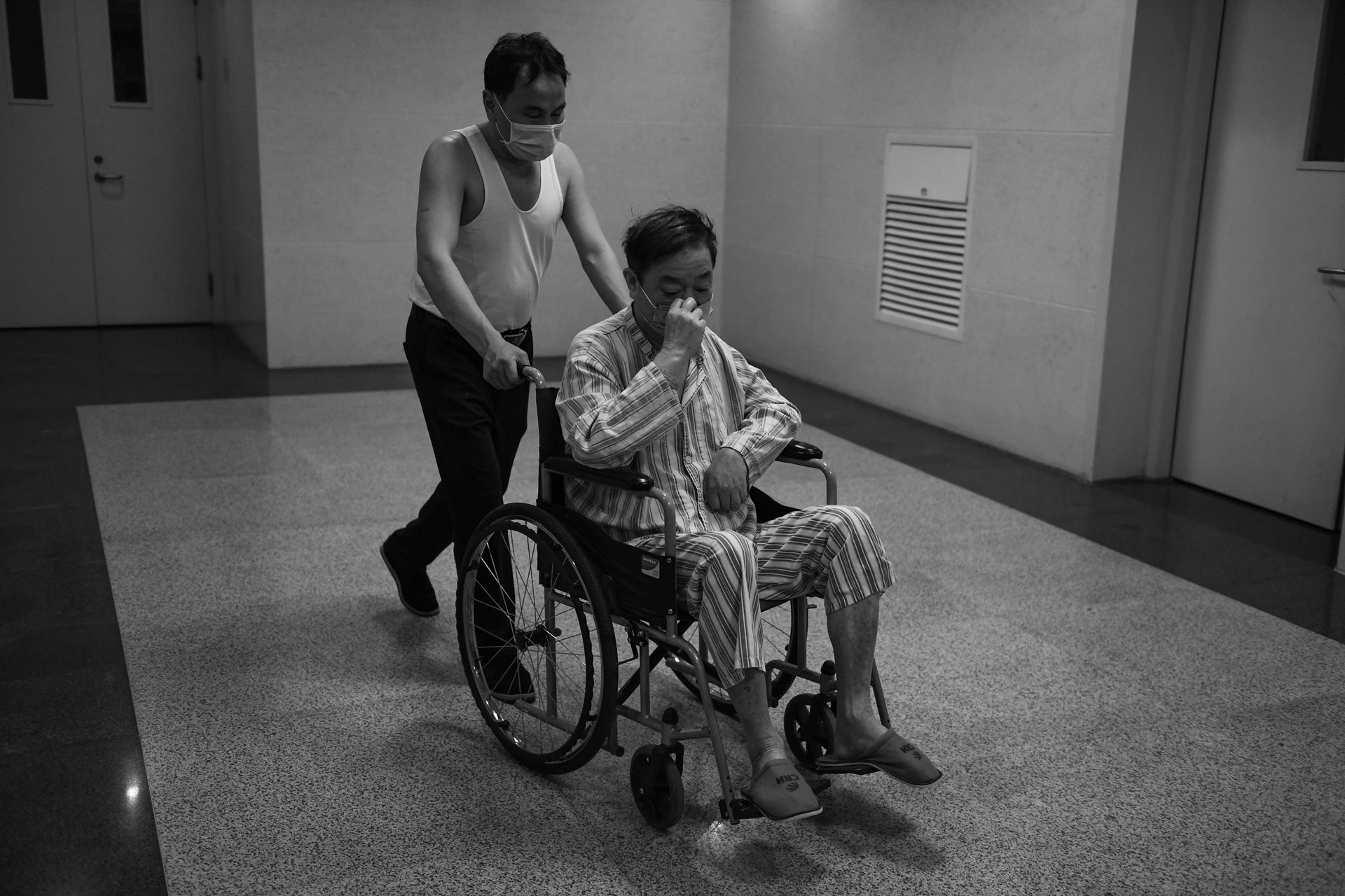 Wu Jingzhou is attended to by a caregiver at the hospital in Hefei, Anhui Province, China. After her husband fell ill, the dual pressure of mental stress and financial strain became an overwhelming burden for Sheng Hailin.