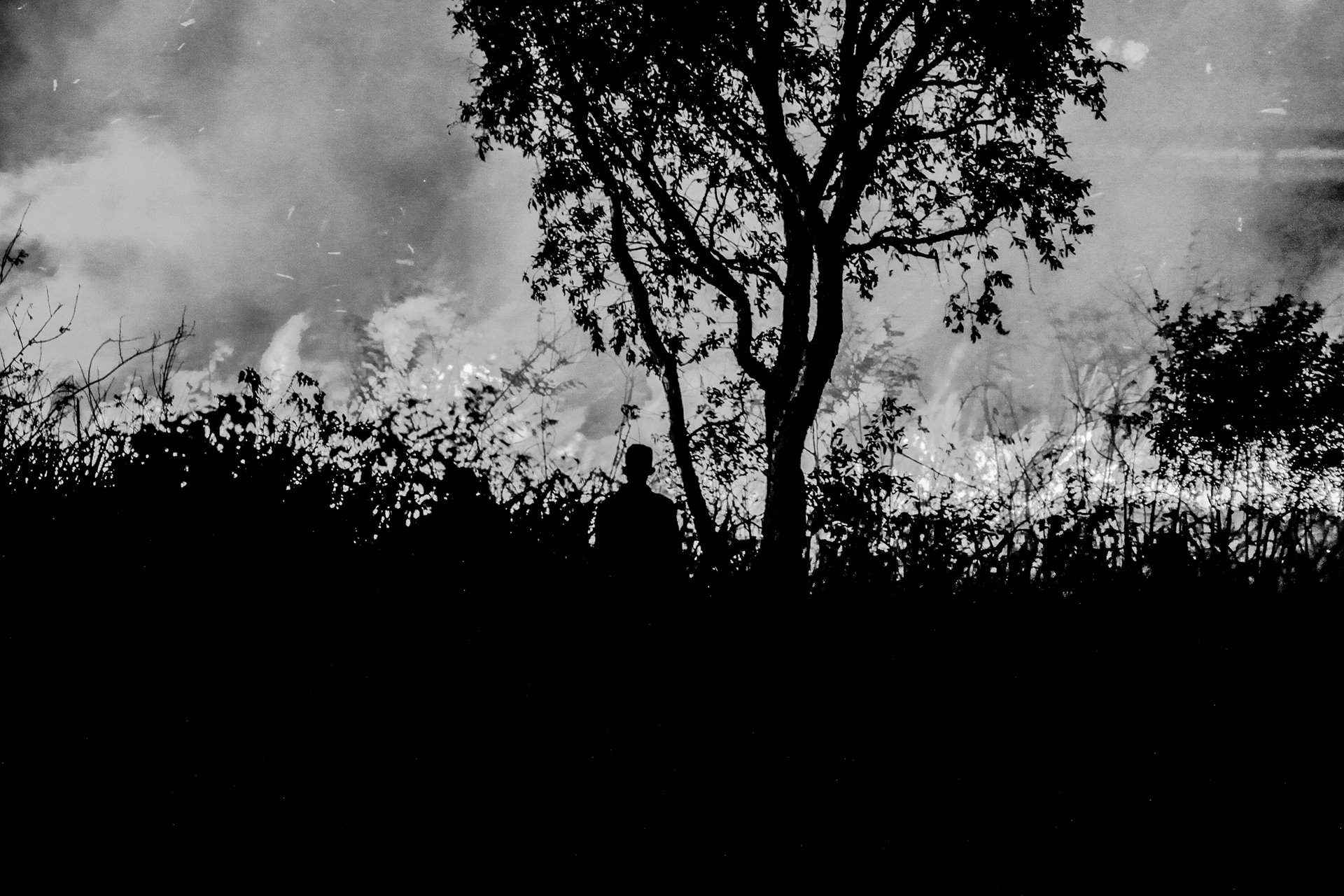 A resident of the village of Pamulut, in Ogan Ilir, South Sumatra, Indonesia, looks on at a blaze from burning peatland.