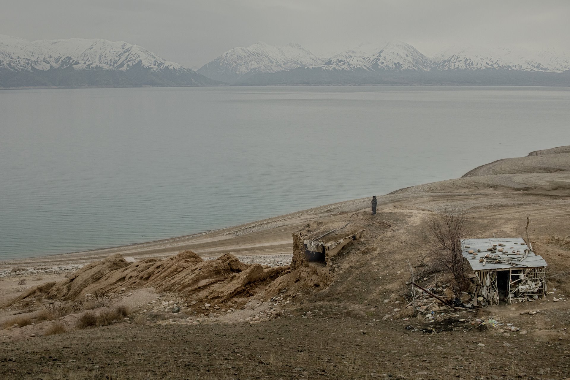 Nurislam Gainutdinov (72) stands near his home beside the Toktogul Reservoir, in Kyrgyzstan. Gainutdinov has had to move his house in response to fluctuating water levels in the reservoir.