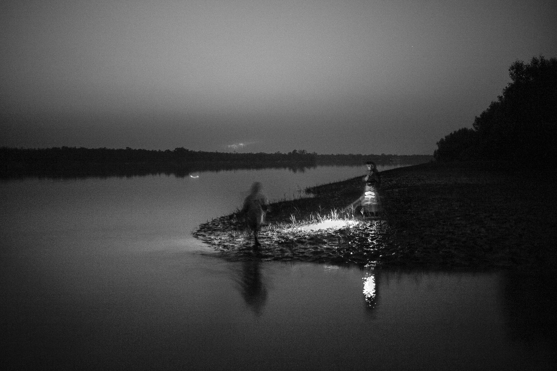 People hunt for crabs at full moon, in the River Ganges, in the Sundarban Tiger Reserve, West Bengal, India.