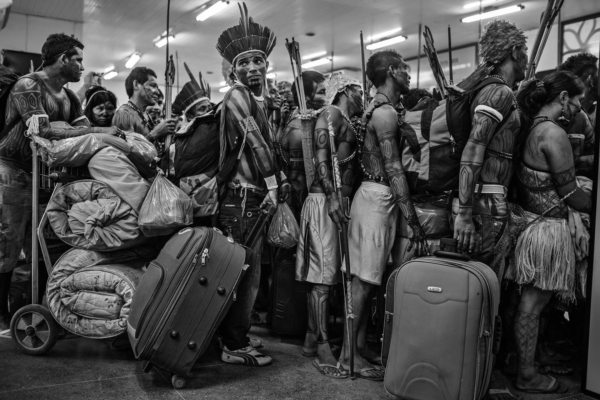 Members of the Munduruku community line up to board a plane at Altamira Airport, in Pará, Brazil. After protesting at the site of the construction of the Belo Monte Dam on the Xingu River, they traveled to the national capital Brasilia to present their demands to the government. The Munduruku community inhabit the banks of another tributary of the Amazon, the Tapajos River, several hundred kilometers away, where the government has plans to build further hydroelectric projects. Despite pressure from indigenous people, environmentalists and non-governmental organizations, the Belo Monte project was built and completed in 2019.