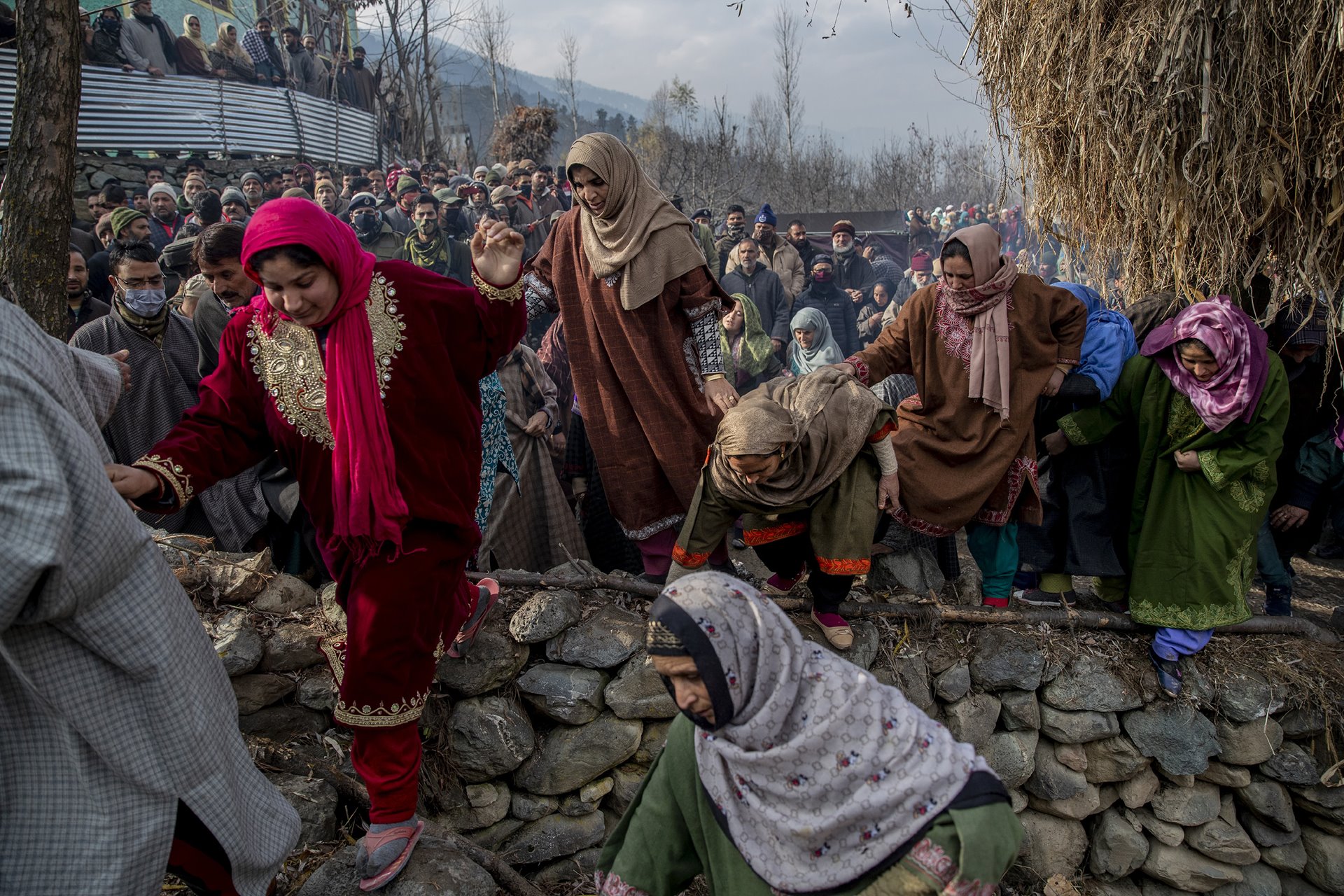 Women cross a stone wall to join the funeral of Constable Rameez Ahmad Baba, who according to Indian police succumbed to his injuries after he was on a bus that was attacked by militants in the Ganderbal district of Indian-administered Kashmir the previous day. At least 11 people were reported injured, and three killed in the attack.