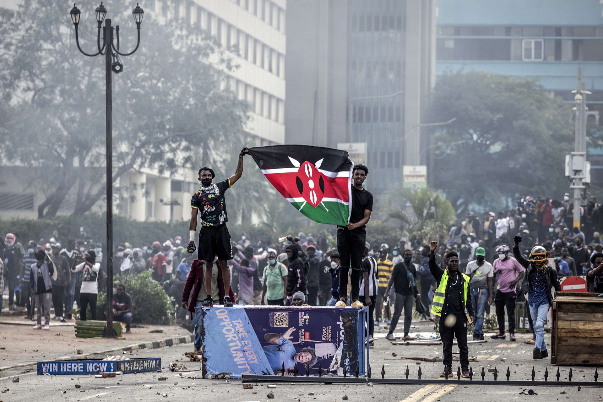 Protestors hold up a Kenyan flag outside the Kenyan Parliament.&nbsp;