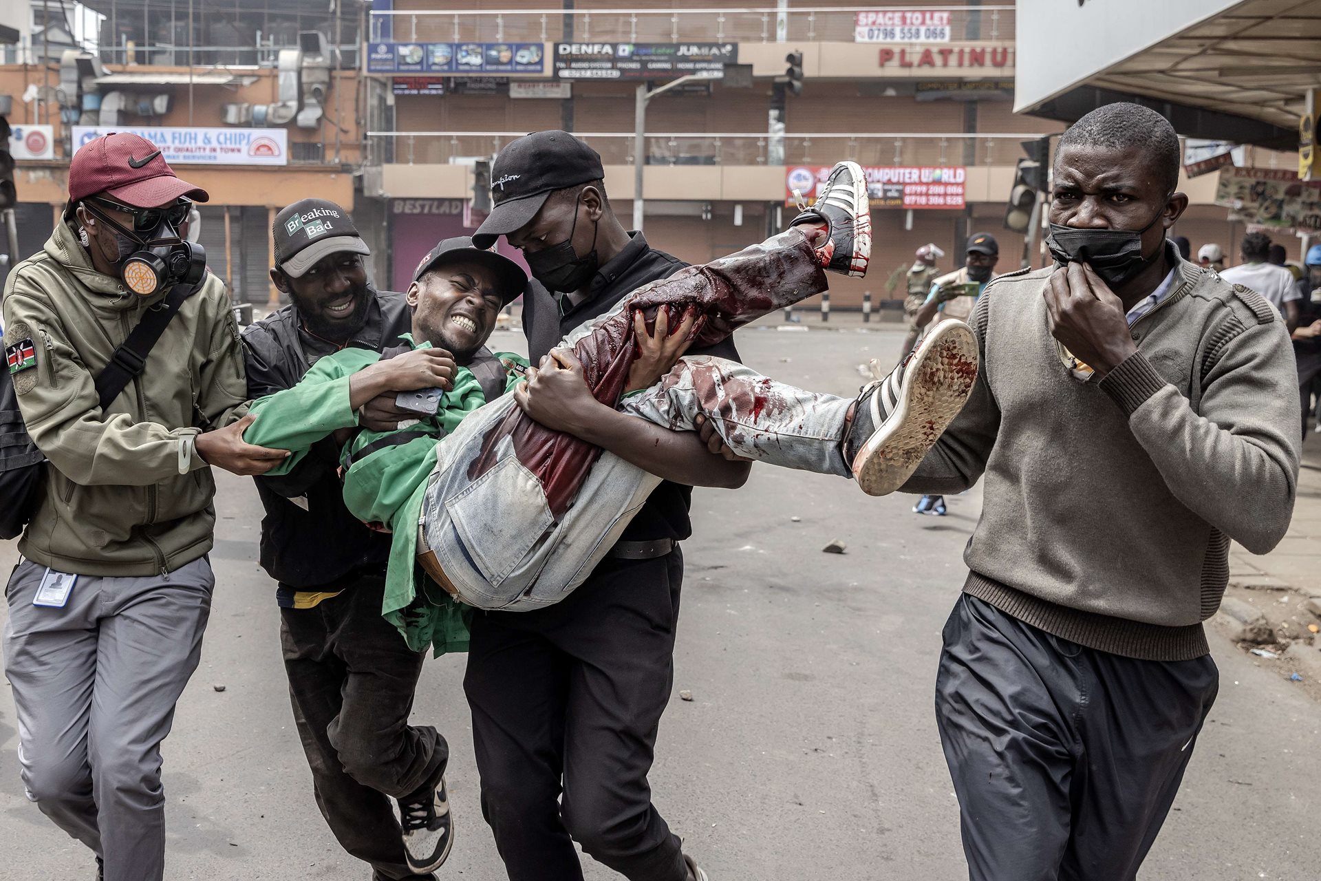Protestors carry a wounded man to safety after weeks of clashes between protestors and police over the finance bill. The violence resulted in at least 60 deaths, 400 injuries, and numerous reports of abduction and police brutality in Nairobi, Kenya.