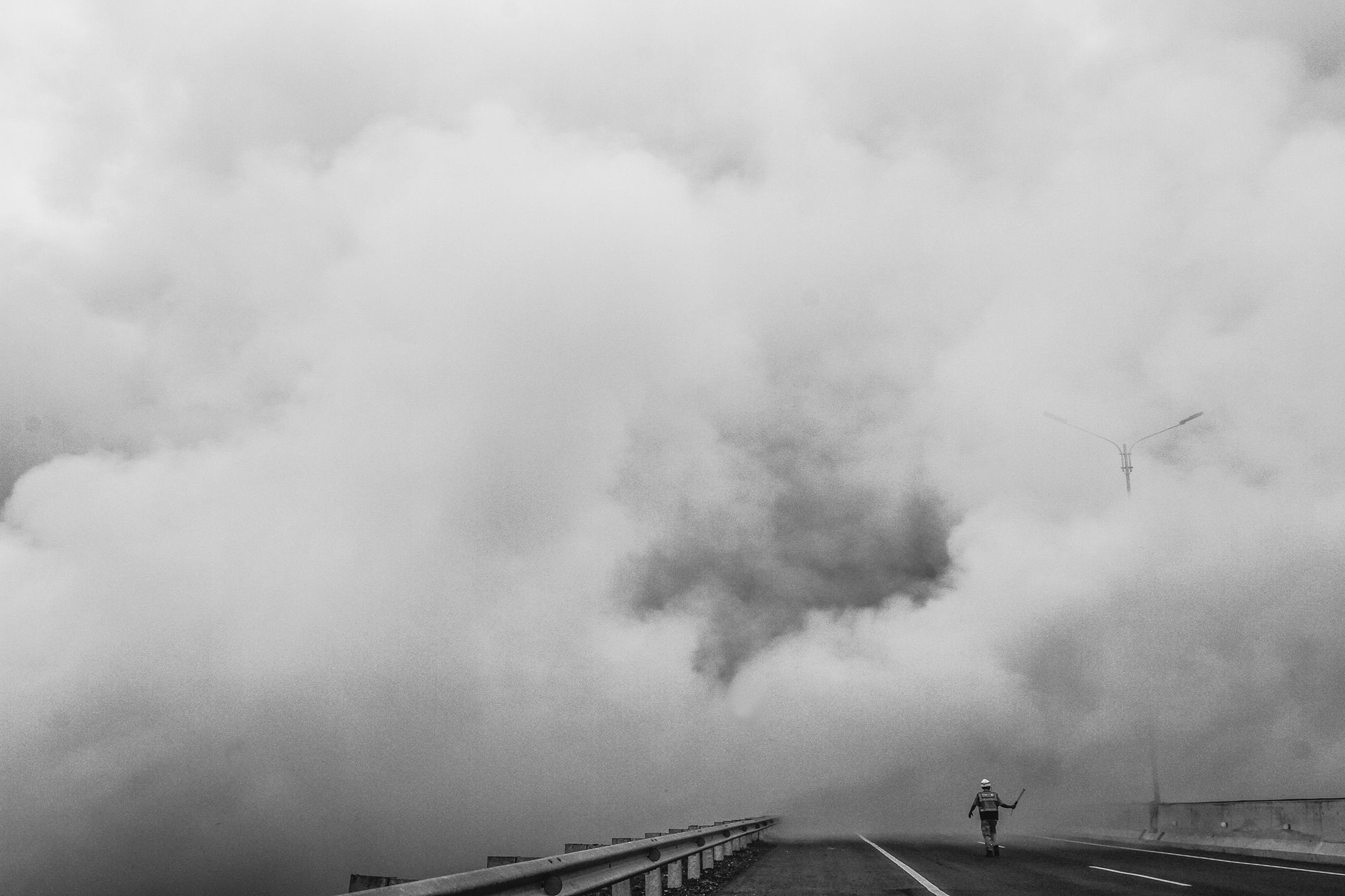 Smoke from peatland fires covers a toll road in Ogan Ilir, South Sumatra, Indonesia, interfering with passing traffic.