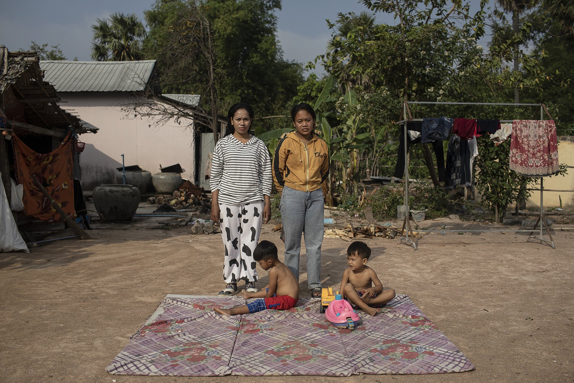 <p>Surrogate mothers Vin Win (right) and Ry Ly (left) were arrested during a raid to fight trafficking in 2018. They live near one another and their children from surrogacy, Korng (3, left) and Phavit (4, right), often play together. Vin Win is separated from her husband who resents the situation. Kampong Speu, Cambodia.&nbsp;</p>
