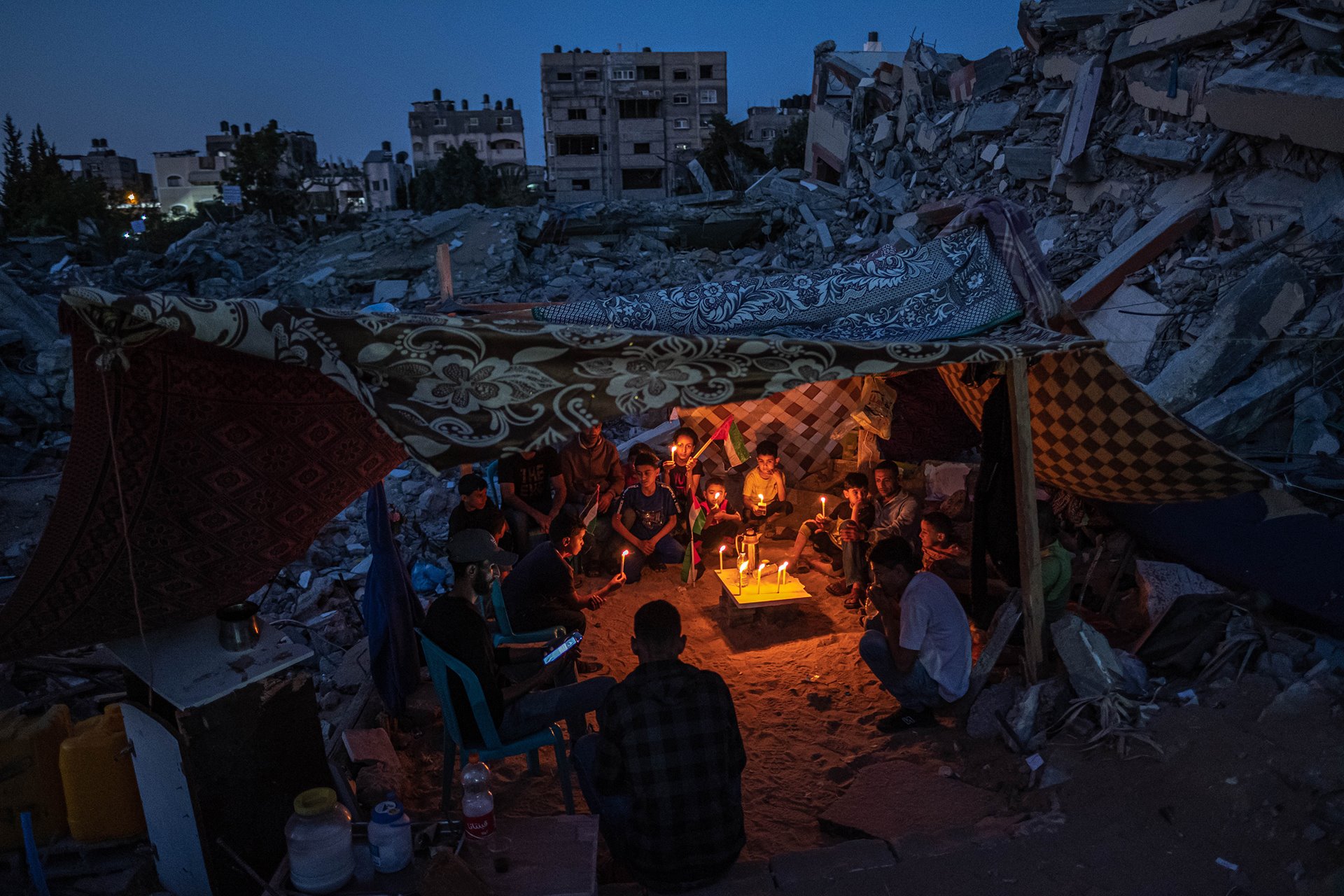 <p>Palestinian children gather with candles in Beit Lahia, Gaza, Palestine, after a protest by children in the neighborhood against attacks on Gaza, during a fragile ceasefire following an 11-day conflict between Hamas and Israel.</p>
