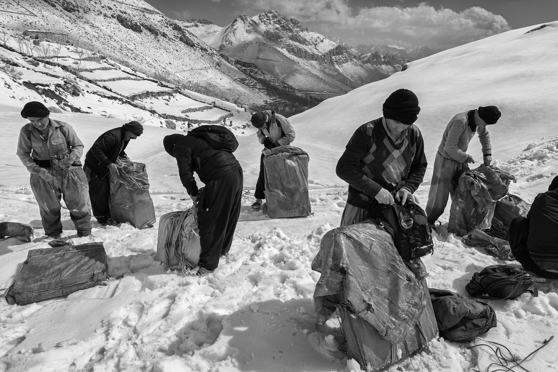 Kolbars carefully change plastic pack covers en route, to ensure they present goods in an optimal condition, in Kurdistan, Iran. They are held financially responsible for the cargo they are delivering, and often have to cover the entire cost of damaged goods.&nbsp;