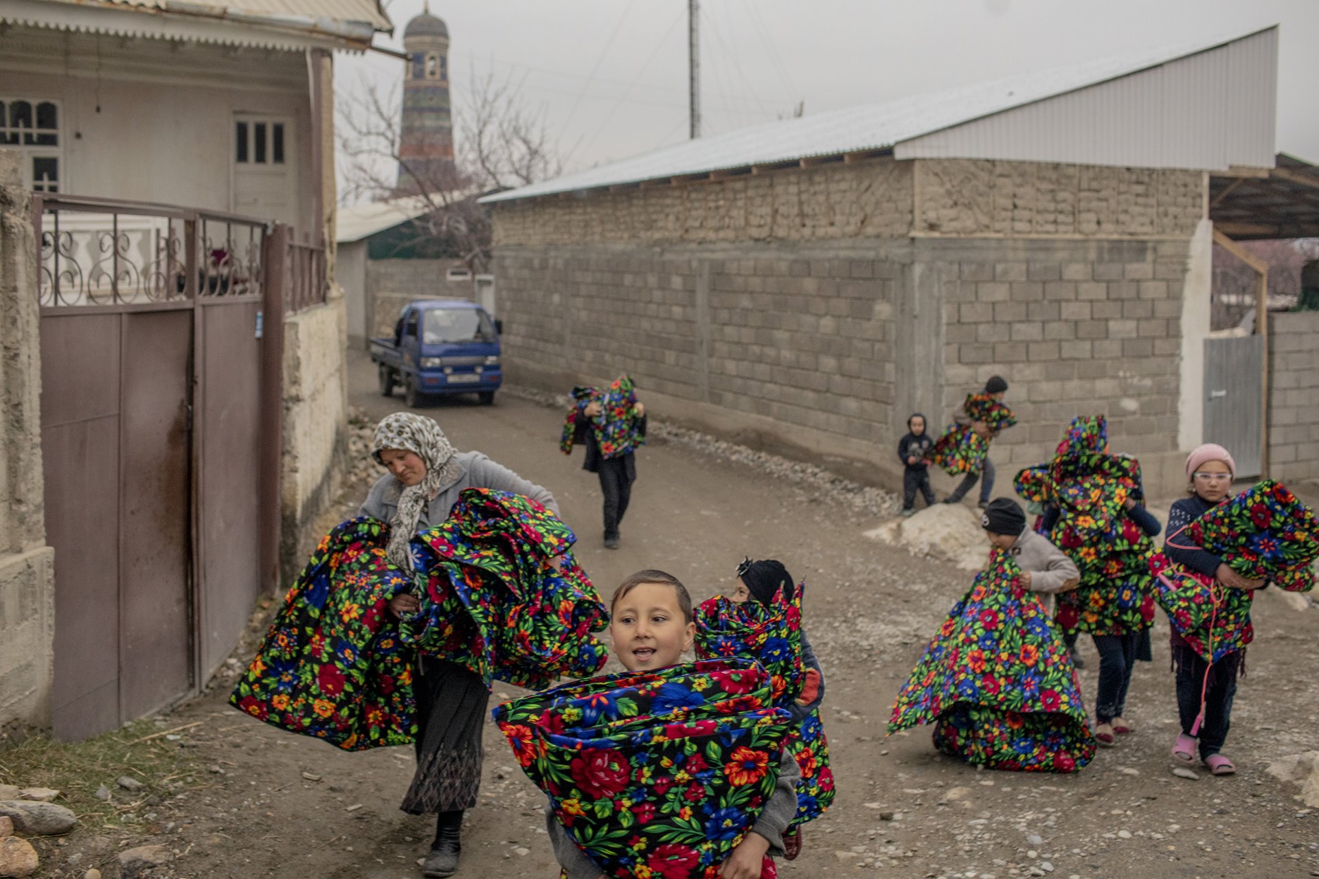 Majnuna Sirojiddinova (37), accompanied by village children, carry kurpacha (traditional cotton mattresses) from the local mosque to be repaired, in Khojai A&rsquo;lo, Tajikistan. Disagreements with Kyrgyzstan over a water distribution source turned into cross-border violence in 2021, affecting residents of Khojai A&rsquo;lo.
