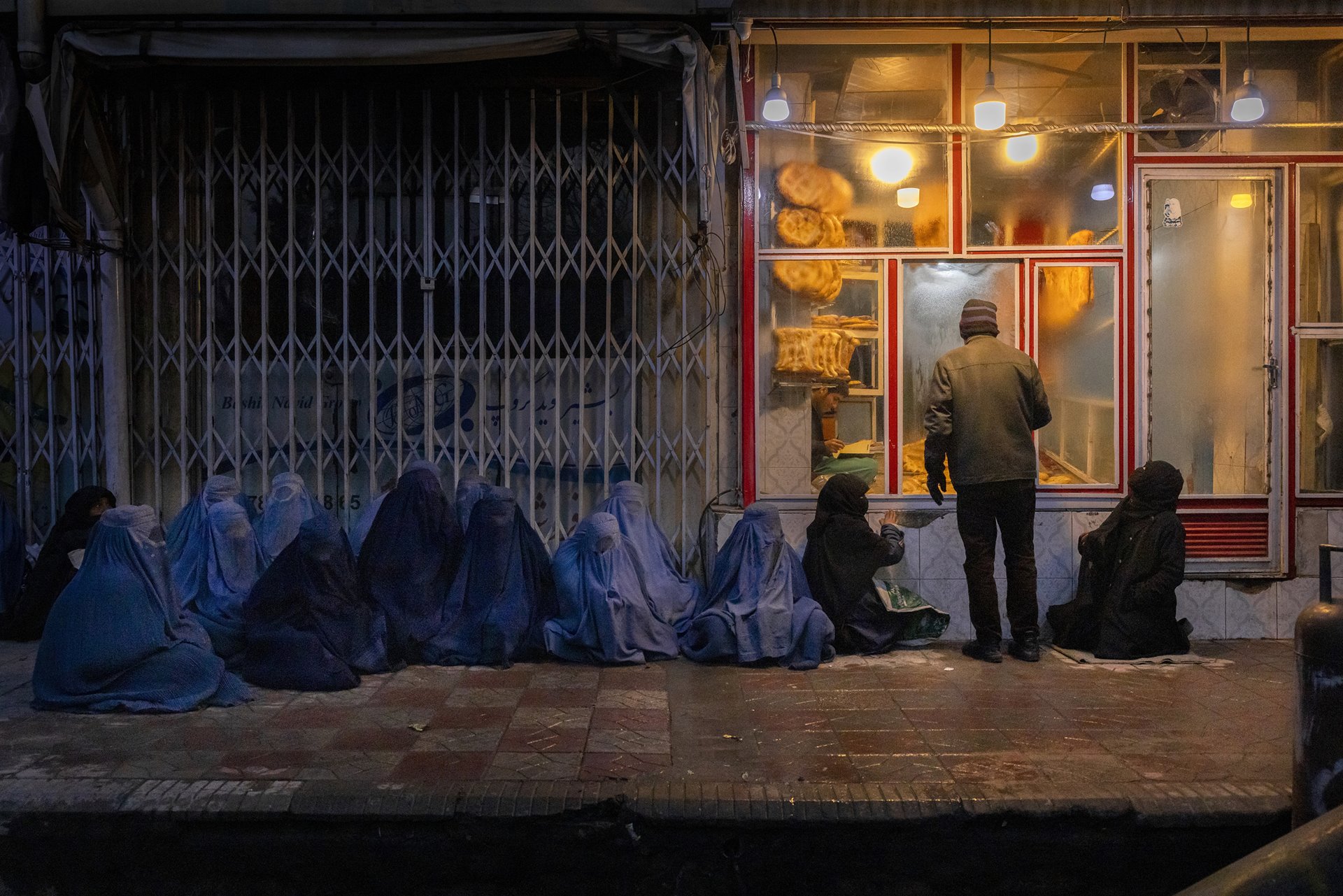 Women and children beg for bread outside a bakery in central Kabul, Afghanistan. Bread is a staple in Afghanistan, but soaring prices have forced more and more people to rely entirely on the compassion of others.