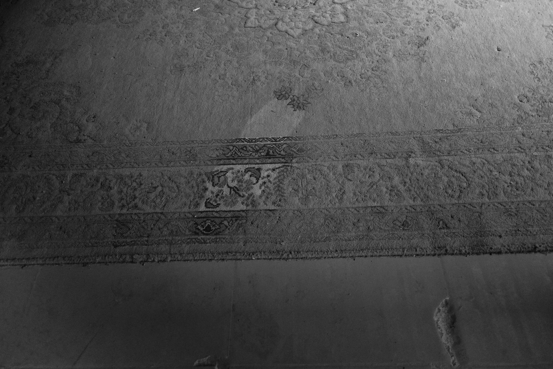 Dust on a rug inside Amal's home. The family sometimes gives up on cleaning as it needs to be done every two hours. Moon Valley, Alexandria, Egypt.