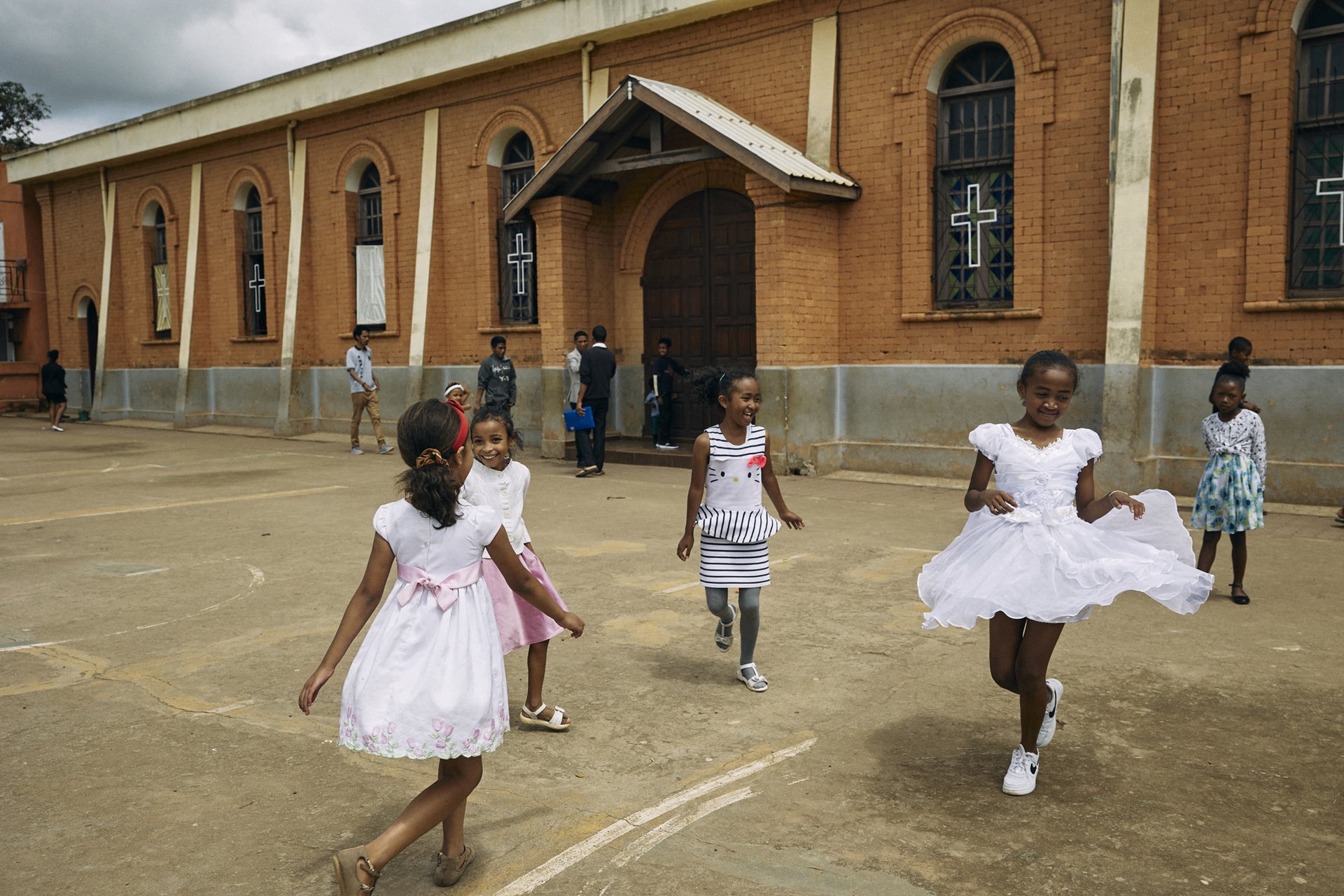 Children play outside the church during the Sunday morning service at the Roman Catholic Church in Mandrosoa Ivato, Antananarivo, Madagascar.