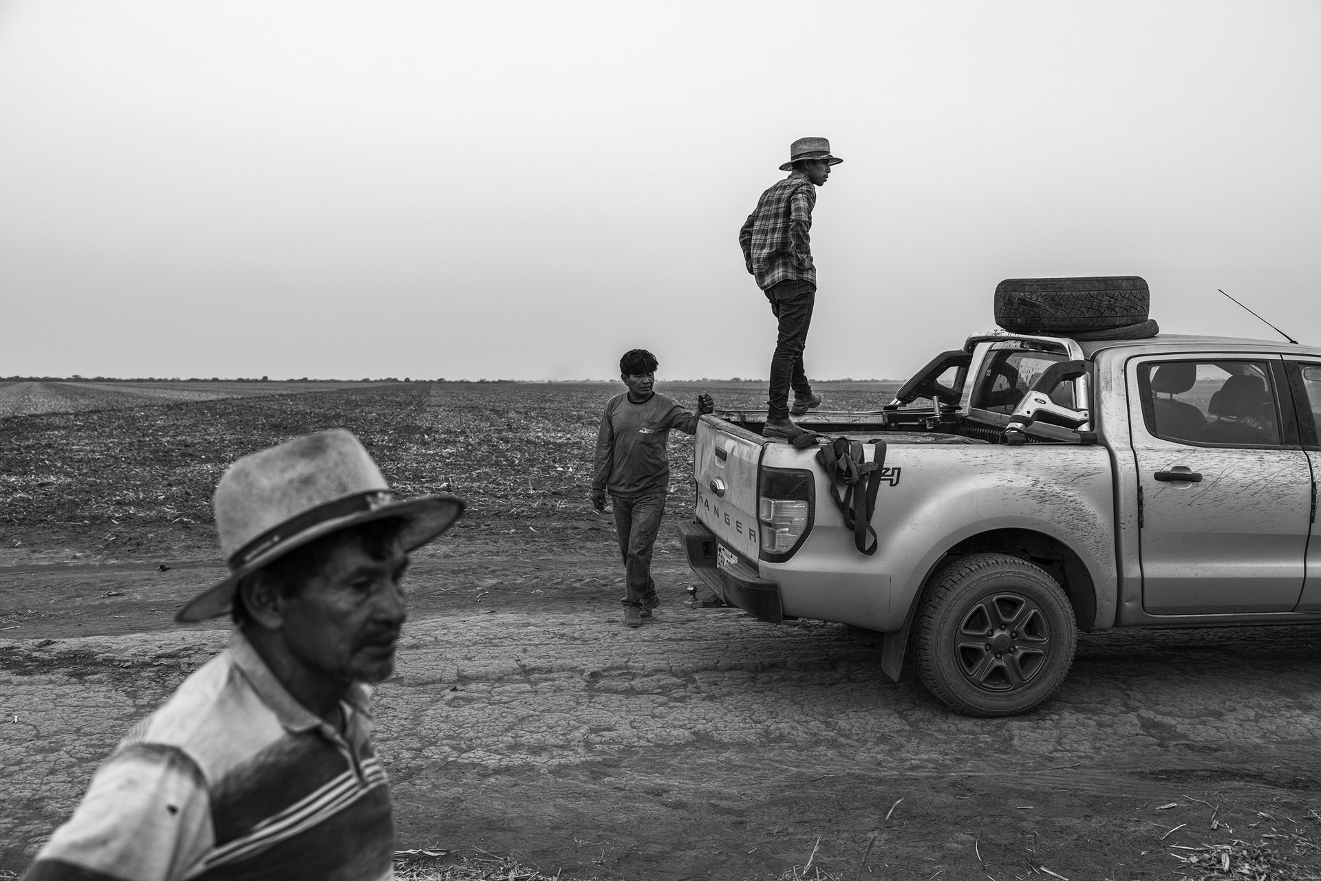 Members of the Manoki community watch tractors spreading lime in preparation for large-scale soybean farming, in Irántxe Indigenous Land, in Mato Grosso, in the Brazilian Amazon.