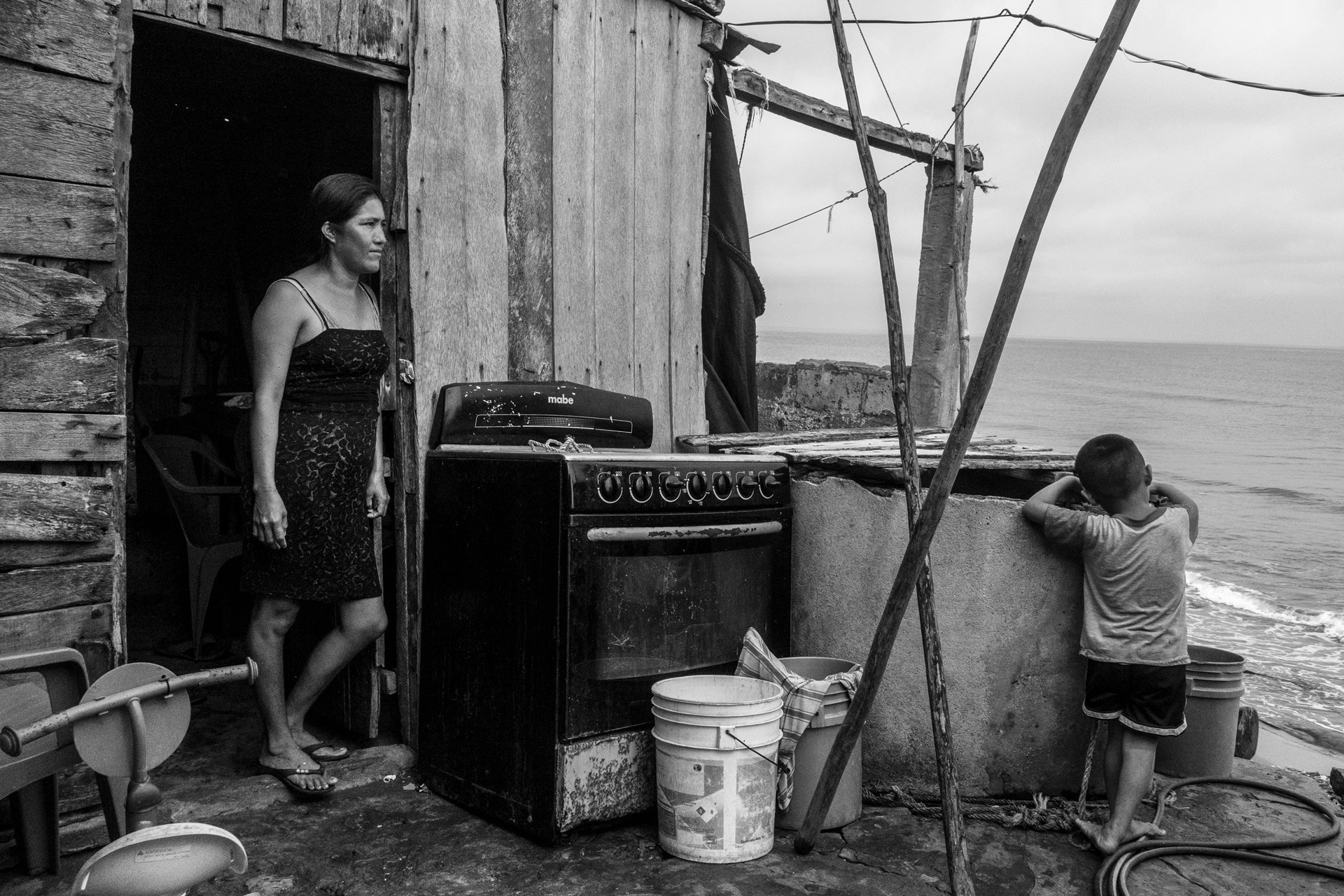 <p>Ms. Marlit watches her son play in the remains of their home, having lost over half the structure to the sea. Sánchez Magallanes, Tabasco, Mexico</p>
<br />
&nbsp;