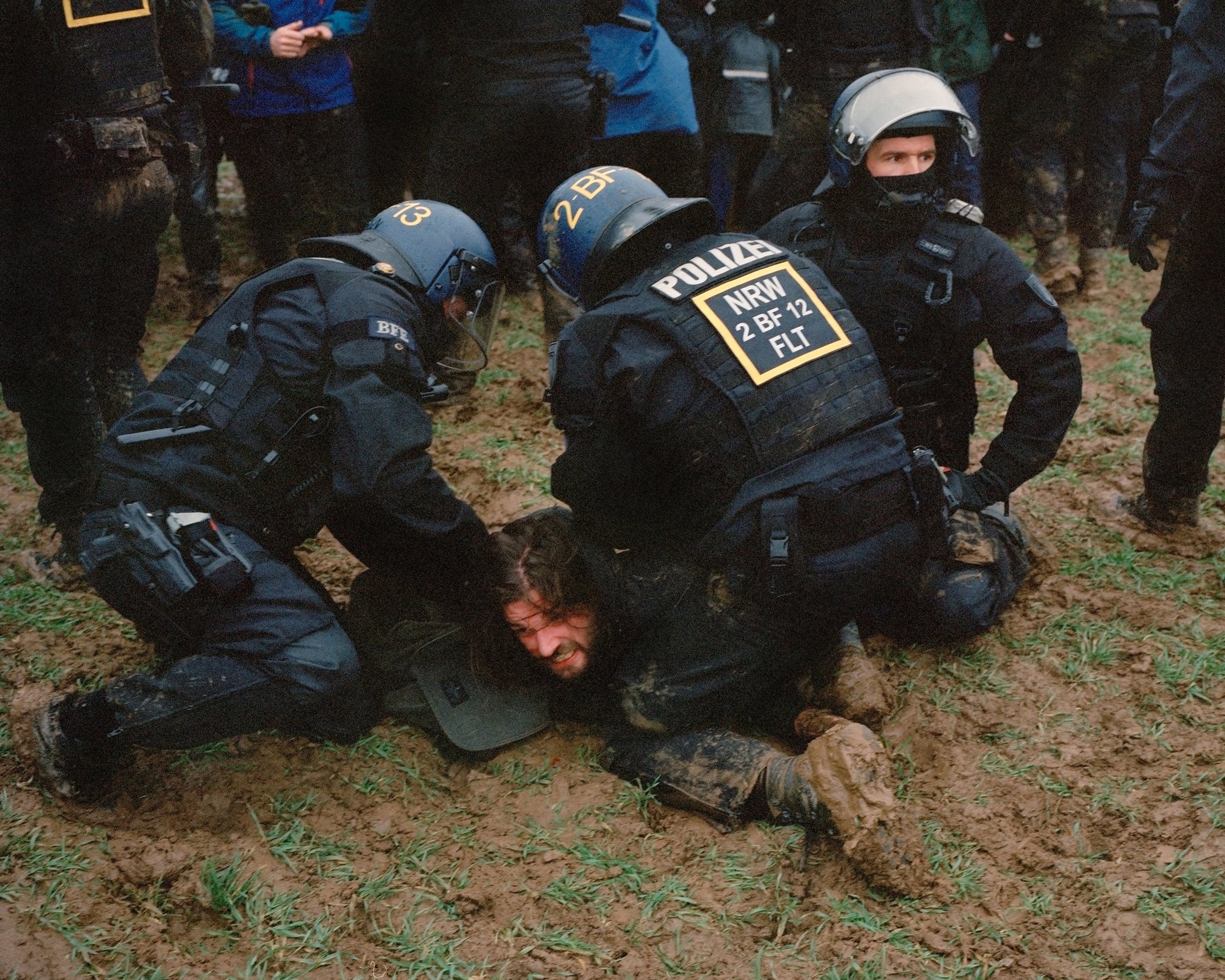 Police officers hold a demonstrator who tried to march towards the village of Lützerath, Germany, to the ground.