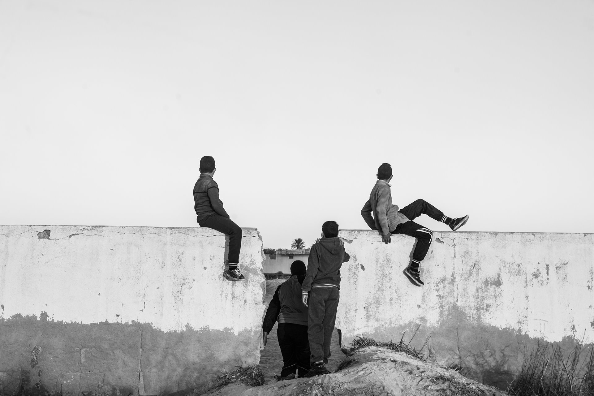 Youths watch a soccer game near a chemical plant in Chott-Essalam, Gabès, Tunisia. Nearly 5,000 people work in the region&rsquo;s chemical industry, but new hires from the region are low. In Gabès, unemployment stands at 24% overall and more than 50% among young people, according to figures reported in 2021 by nonprofit newsroom Coda Media.