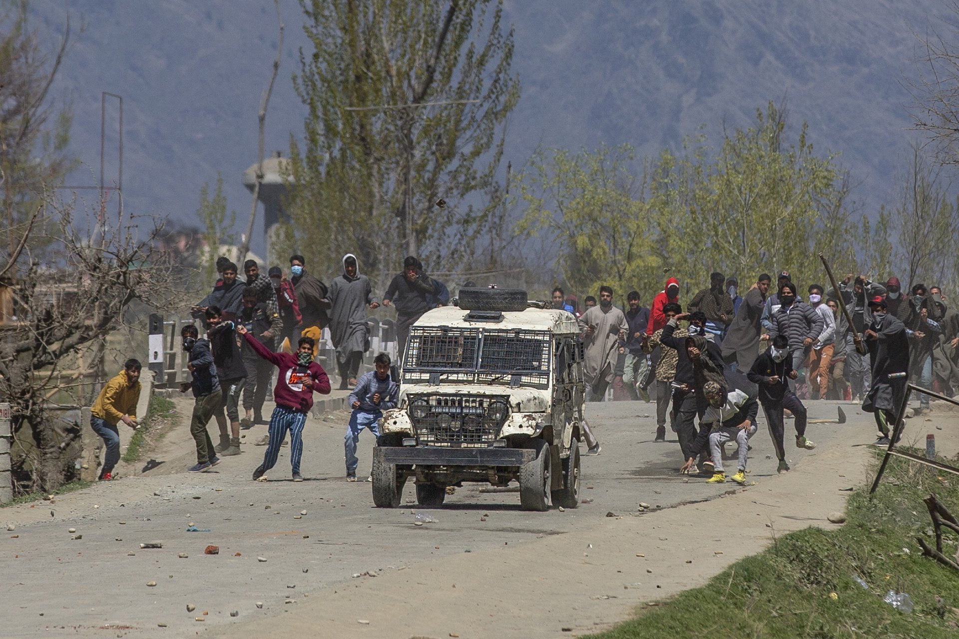 Kashmiri villagers throw stones and bricks at a vehicle belonging to Indian police, during a protest near the site of an earlier gun battle between militants and police in Kakapora, south of Srinagar, in Indian-administered Kashmir.