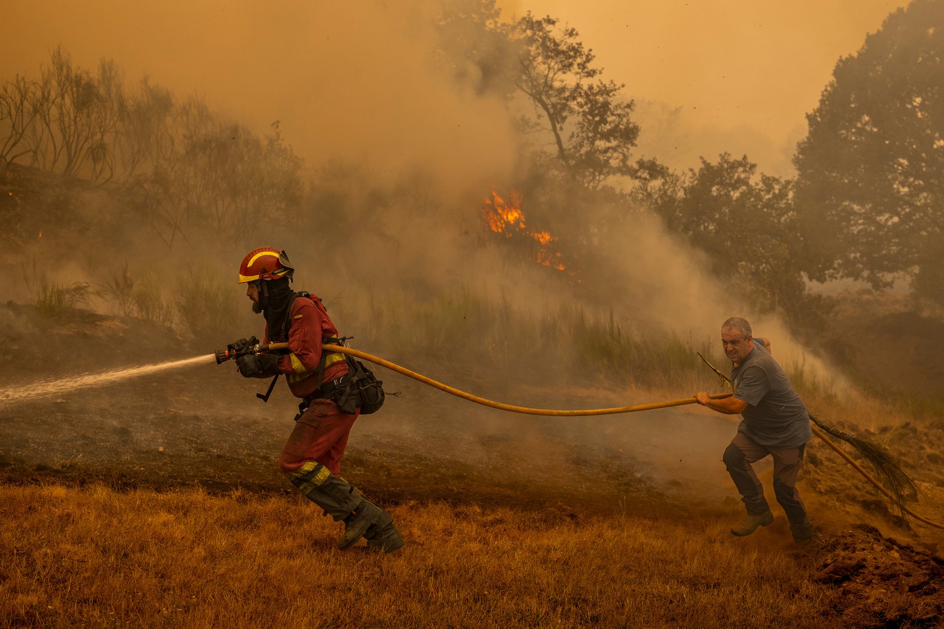 A member of Spain&rsquo;s Military Emergency Unit (UME) and a local resident fight a wildfire in Chandrexa de Queixa, Ourense, Galicia, Spain.