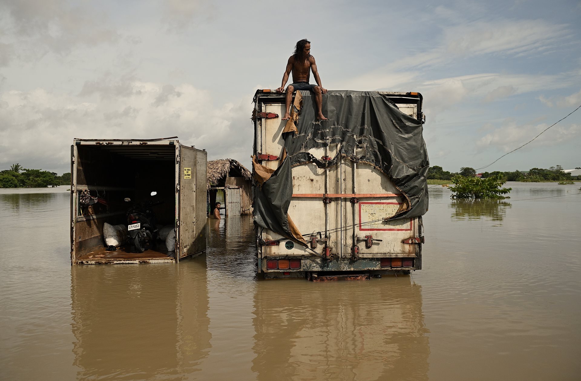 A worker sits on top of a truck stranded by floods in Naga, Camarines Sur, northern Philippines, after continuous rains caused by Tropical Storm Trami. The storm caused extensive damage to roads and bridges, disrupting transportation and communication lines.&nbsp;