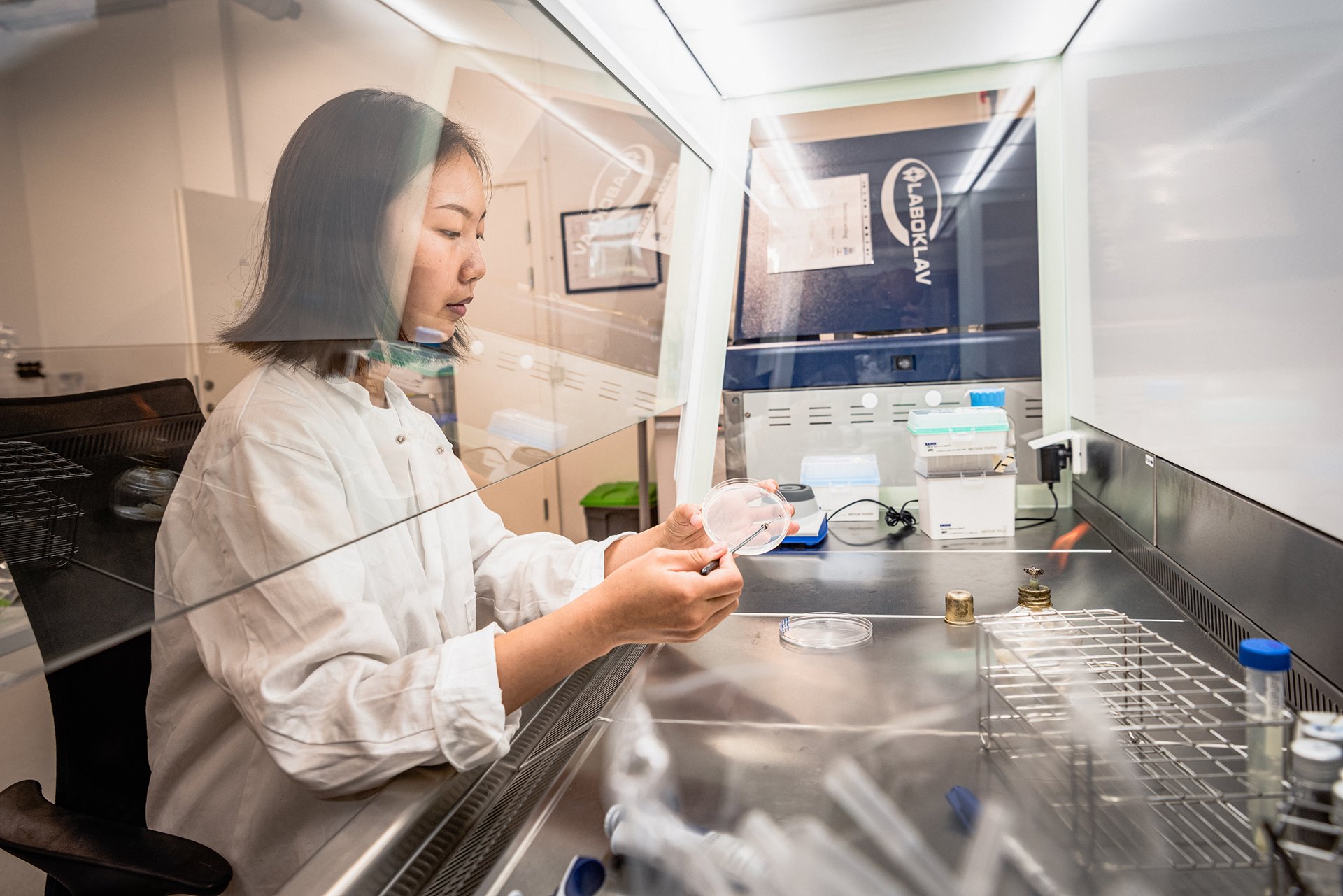 Von Yi Yap, a biotechnician, examines a small sample of a bio fertilizer at an indoor vertical farm in Copenhagen, Denmark. The farm produces microbial biofertilizers for its own use, made onsite from fermented plant waste.