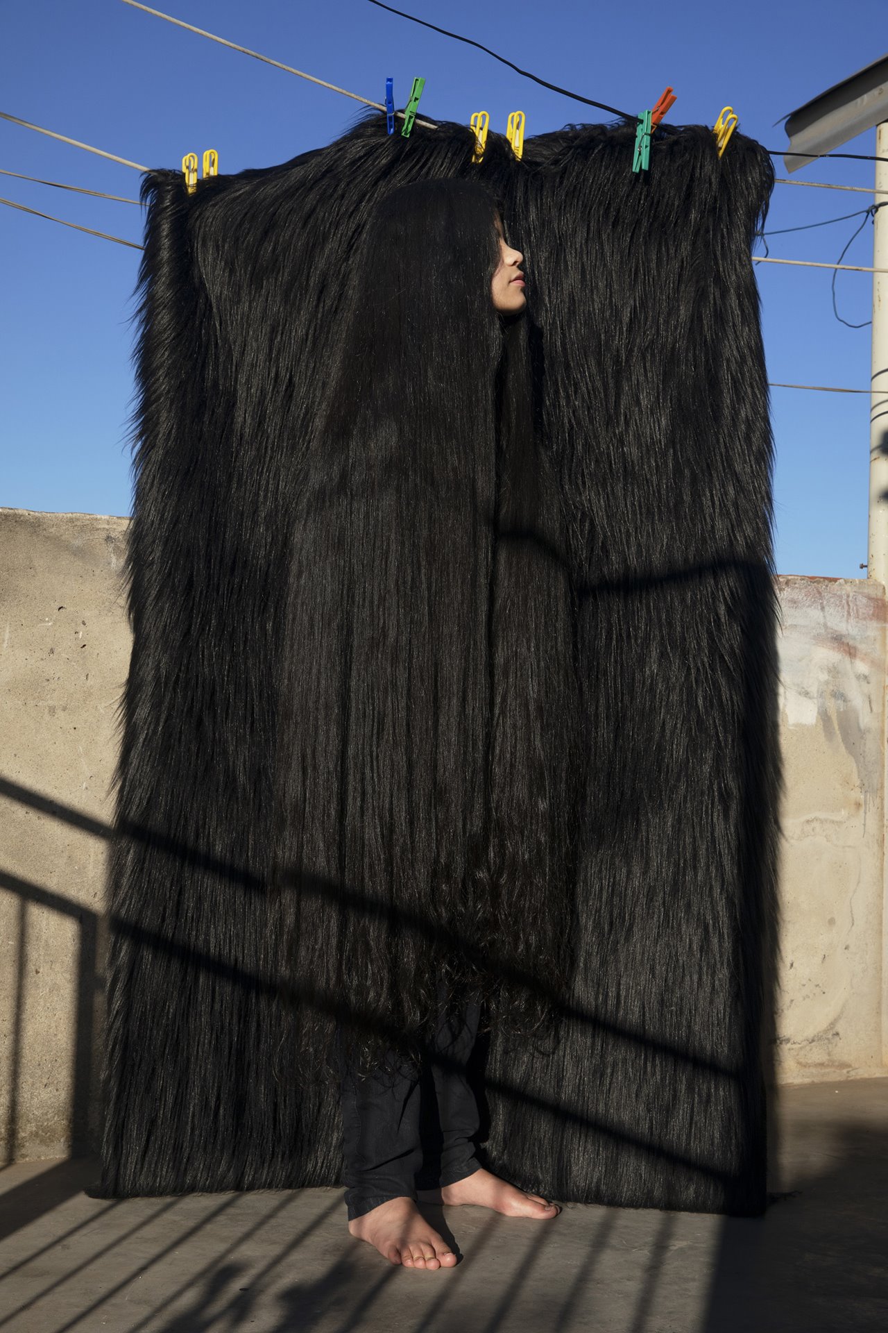 <p>Antonella stands in front of a fake fur blanket, on the rooftop terrace at her family&#39;s home in Buenos Aires, Argentina. She goes up to the terrace to wash clothes and enjoy the sun every day. The disruption to routines, education, recreation, as well as concern for family income and health is leaving Antonella feeling afraid, anxious and concerned about her future.</p>
