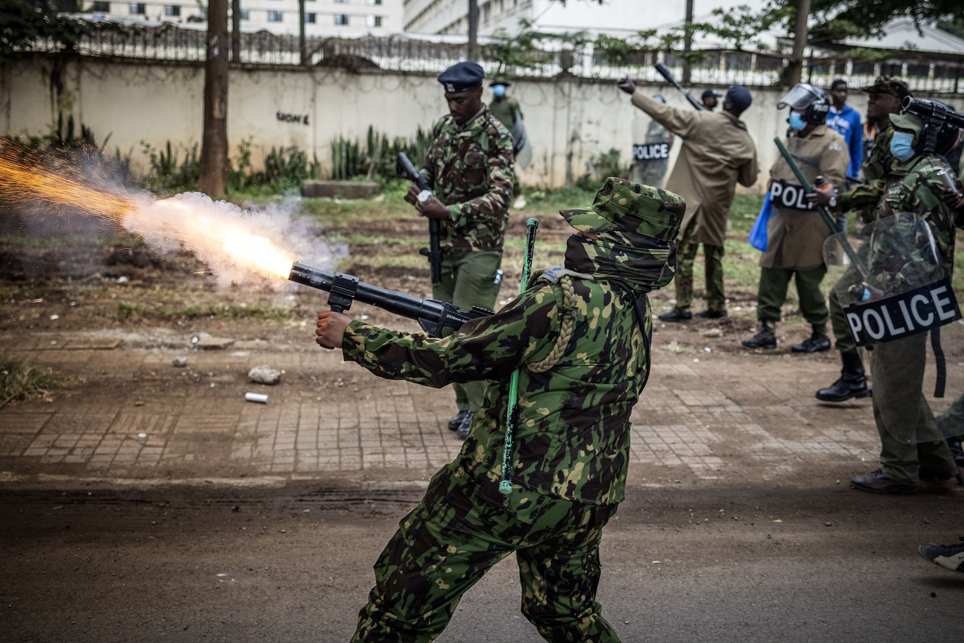 A Kenyan police officer fires a tear gas canister during a demonstration against tax hikes as Members of Parliament vote on the Finance Bill 2024 in downtown Nairobi, Kenya.