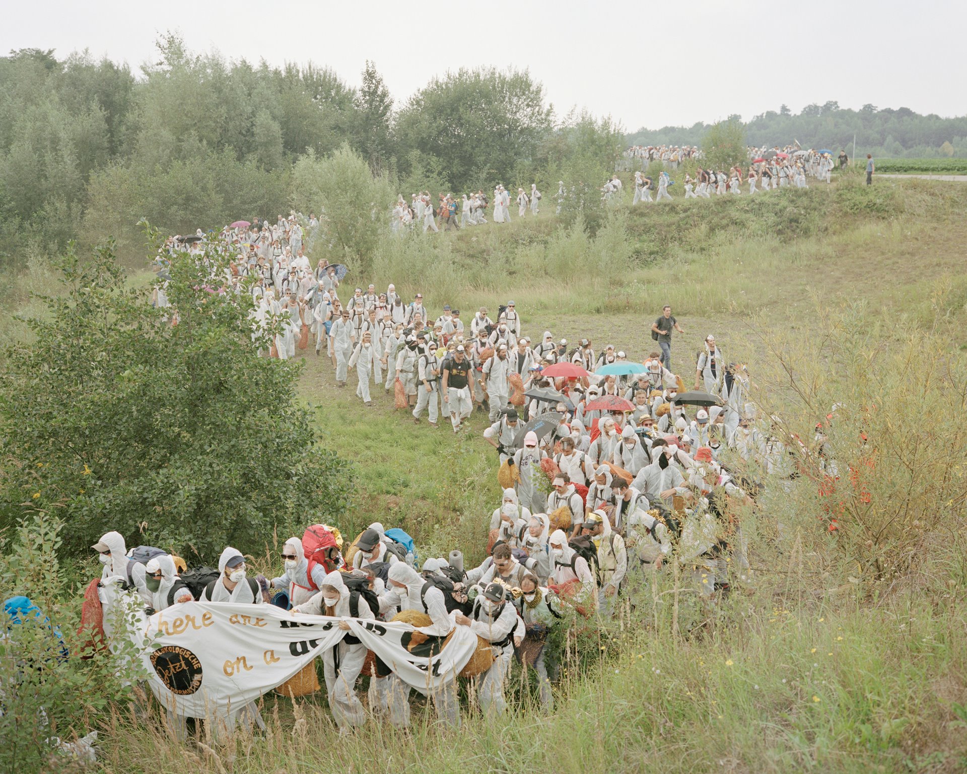 Demonstrators in Bedburg, Germany, evade a police blockade then climb back onto the road to reach the railroad track along which coal travels from Hambach open pit mine to the Niederaussem, Neurath, and Frimmersdorf power plants. According to a 2019 Energy Transition study, these plants emit some 75 million tons of CO2 annually.&nbsp;