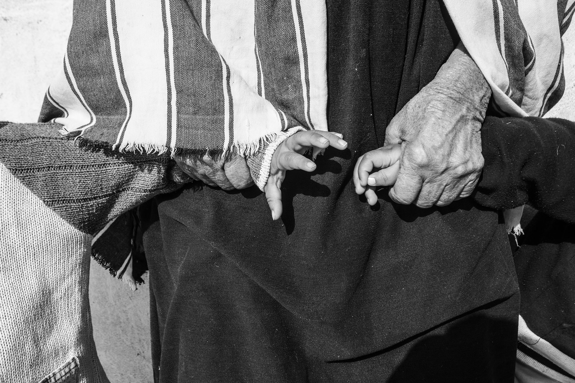 A grandmother joins her grandchildren&rsquo;s hands, in Tabeddit, Gafsa, Tunisia.