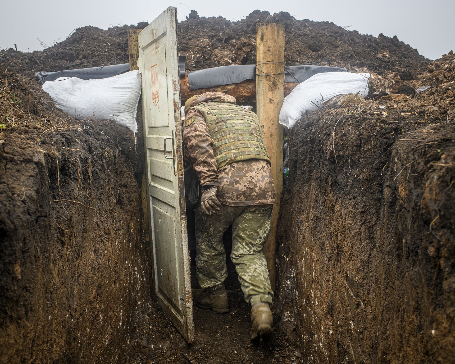 A soldier enters a shelter in a new trench dug by Ukrainian military forces after withdrawal of both Ukrainian and pro-Russian forces for an area of one kilometer along the front near the town of Zolote, in Donbas, Ukraine. The withdrawal was made possible by the observance of ceasefires.&nbsp;