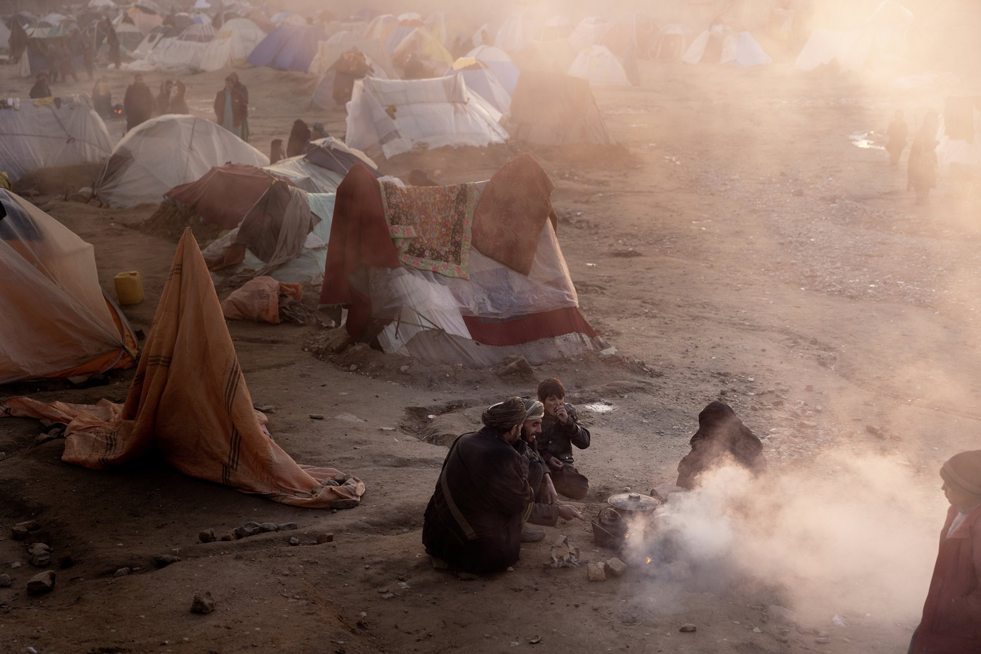 <p>A family burns plastic to make a fire for cooking food in a camp on the outskirts of Herat, Afghanistan. Thousands of people are moving into informal camps as a result of drought and the food crisis, according to Amnesty International. They are desperately in need of help, but so far they have waited in vain due to the lack of foreign aid and the incompetence of the ruling Taliban government.</p>
