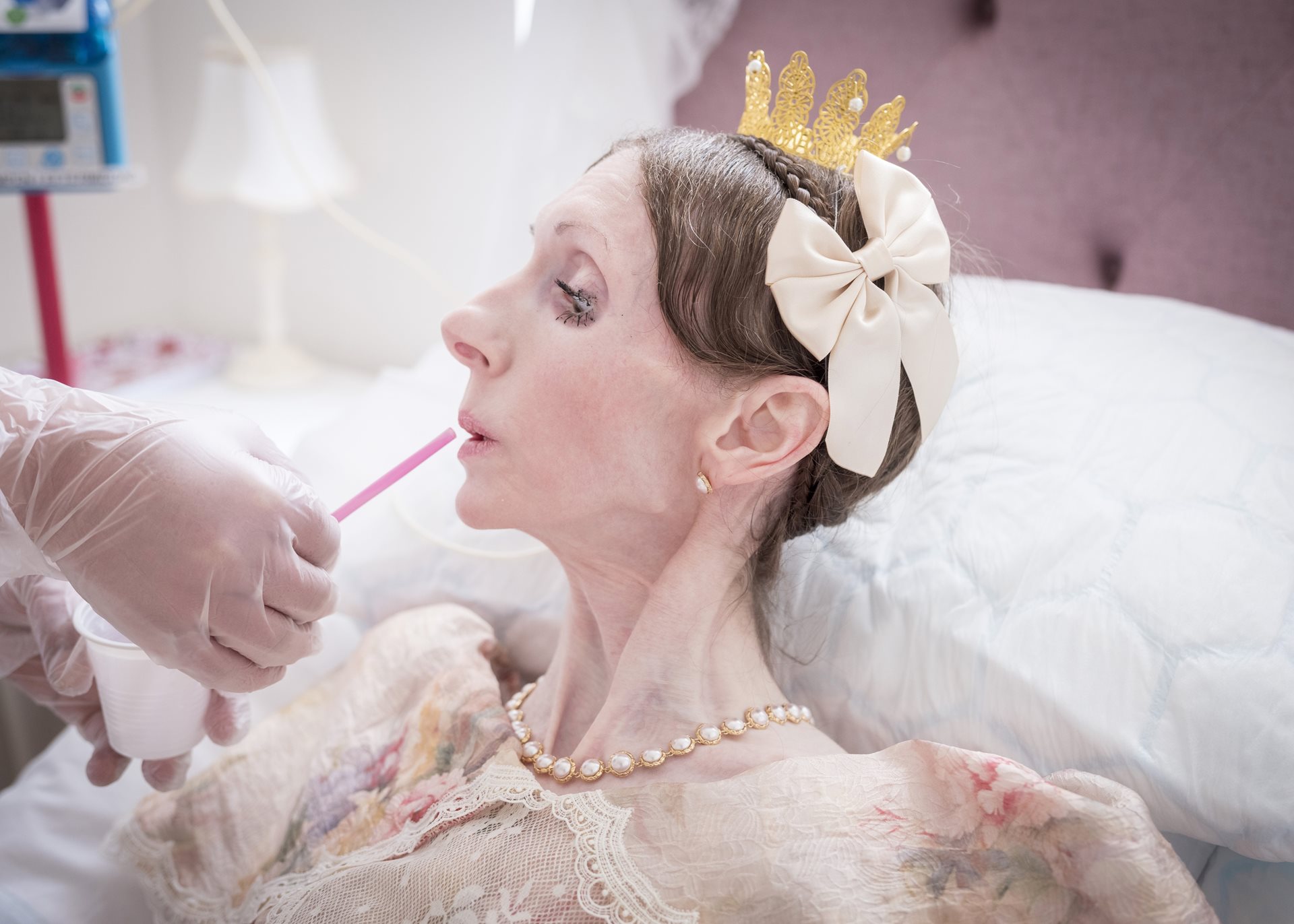 An assistant helps Engla Louise drink through a straw at her home in Linköping, Sweden. She previously had daily visits from nurses; now her care relies on a special arrangement involving healthcare services and the municipality.&nbsp;<br />
&nbsp;
