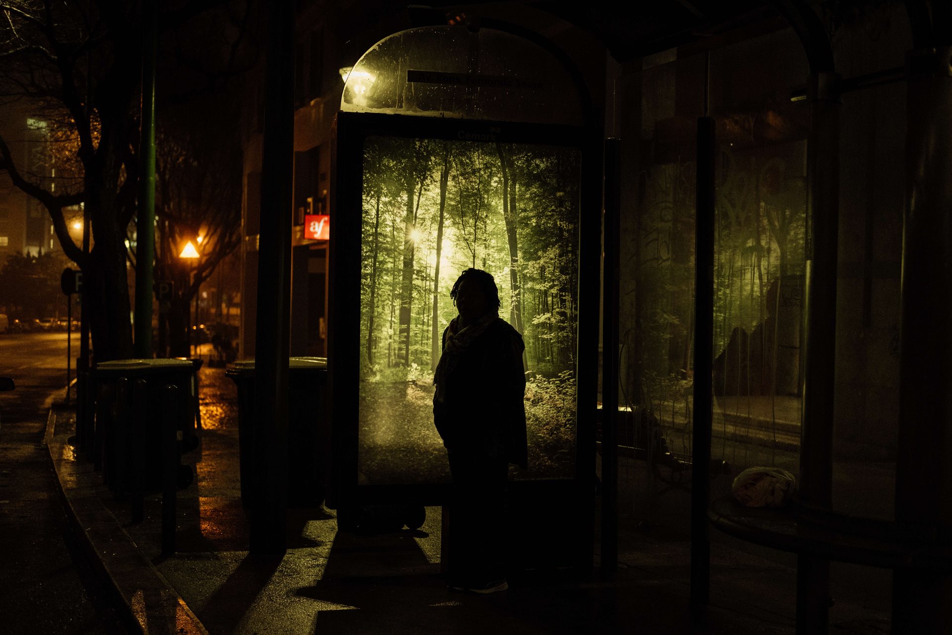 Ana Maria waits for a bus at dawn as part of her 20-kilometer commute into work, in Lisbon, Portugal.