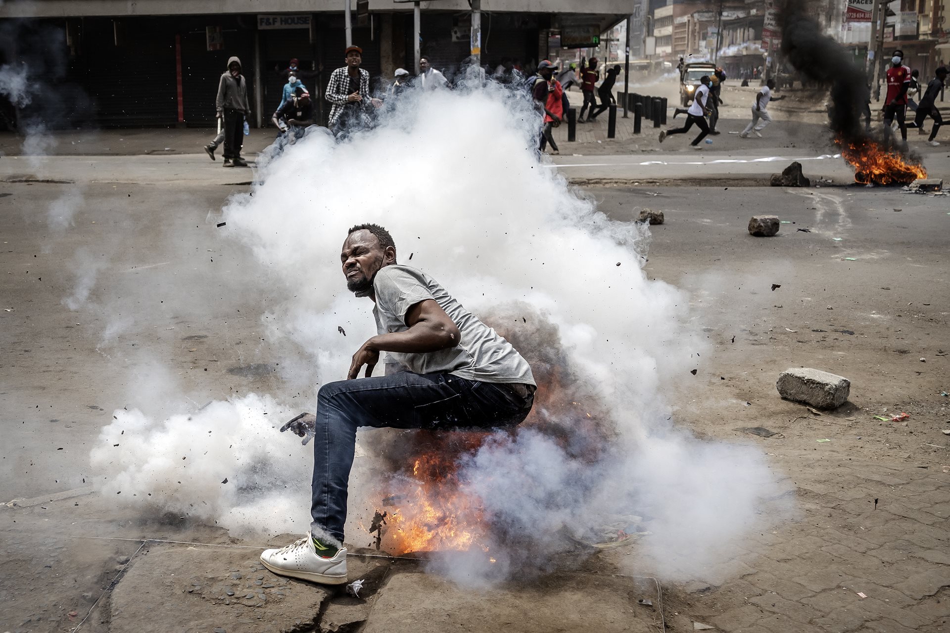 A tear gas canister explodes under a protestor in Nairobi, Kenya.