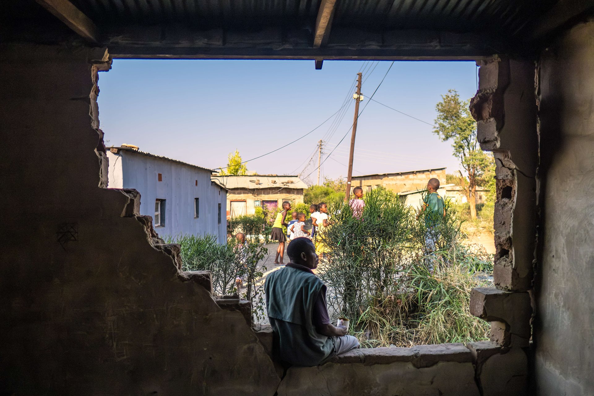 John Chikopa (52) sits on the broken wall of his cousin&#39;s home, which was recently destroyed by a group of elephants. A tenant sleeping in the next room at the time narrowly avoided injury. &ldquo;It&#39;s getting worse,&rdquo; said Chikopa. &ldquo;Sometimes you don&#39;t even want to go out of your house.&rdquo; Livingstone, Zambia