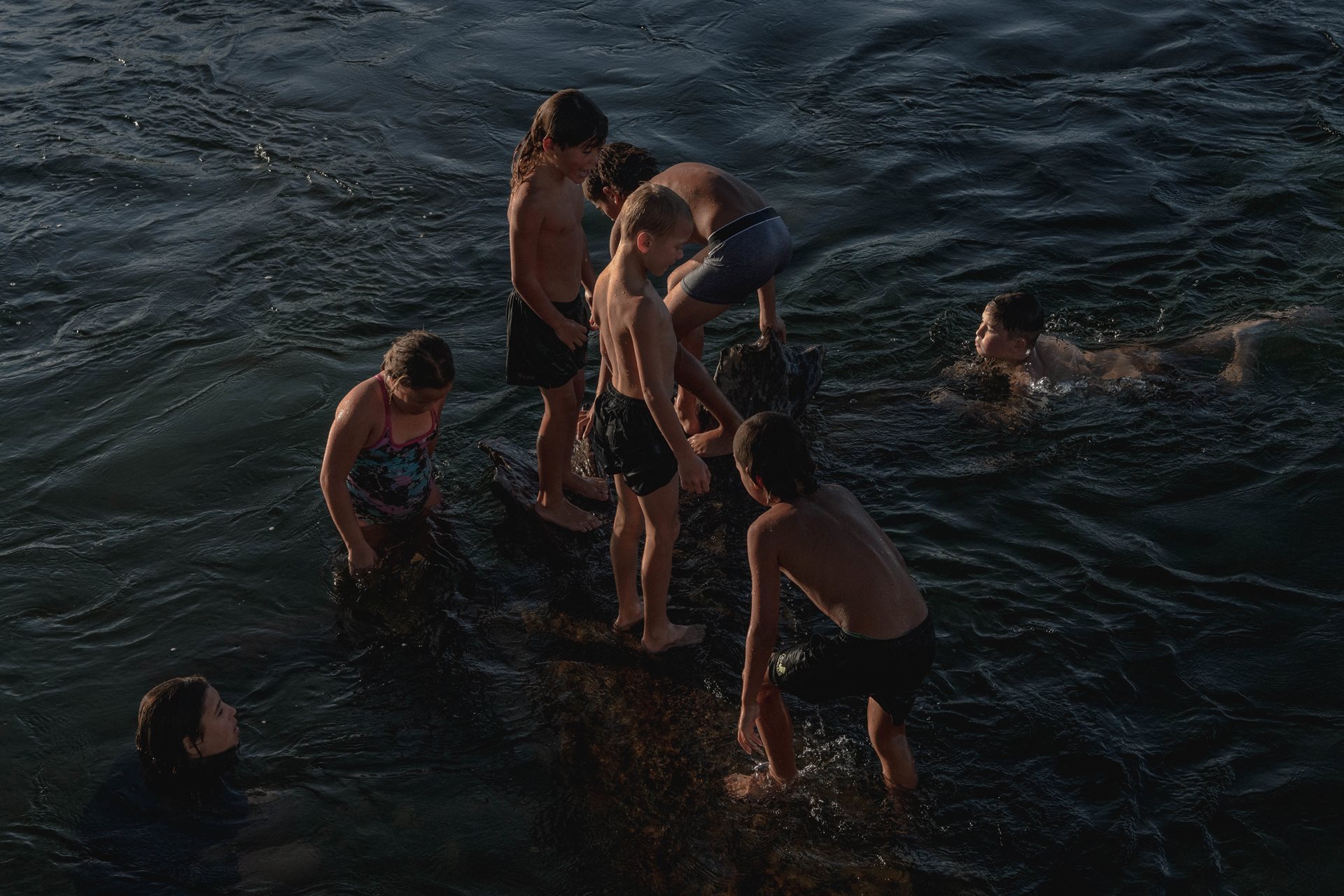 Children of the Teepa family and their cousins swim in the Ōhinemataroa (Whakatane) River, in Ruatoki, New Zealand, watched over by older Teepa siblings.
