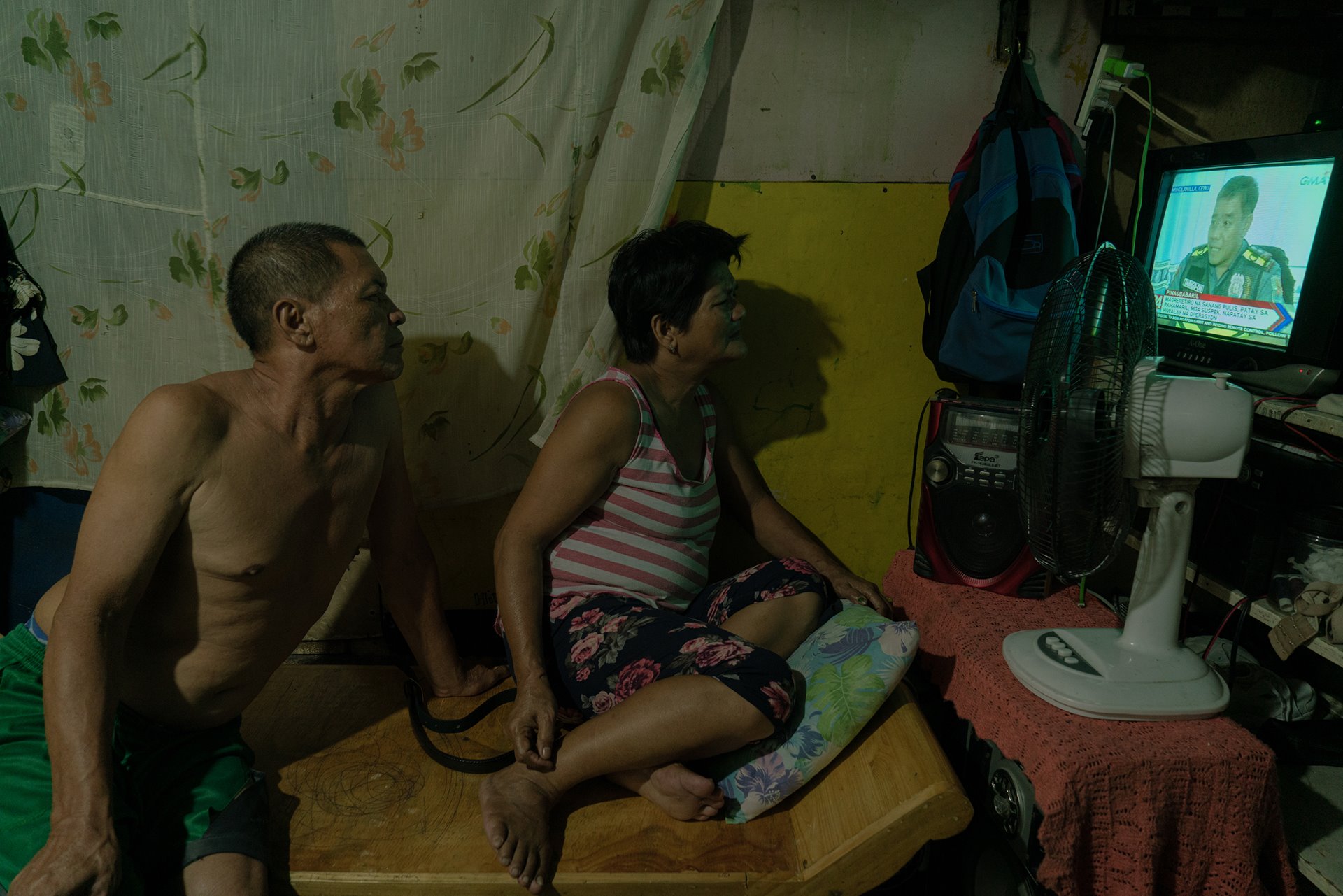 <p>Nestor and Alma Hilbano watch the evening news, in Quezon City, the Philippines. Exactly three years earlier, their son Richard was killed during a police operation &ndash; an event that was reported on the news at the time.</p>
