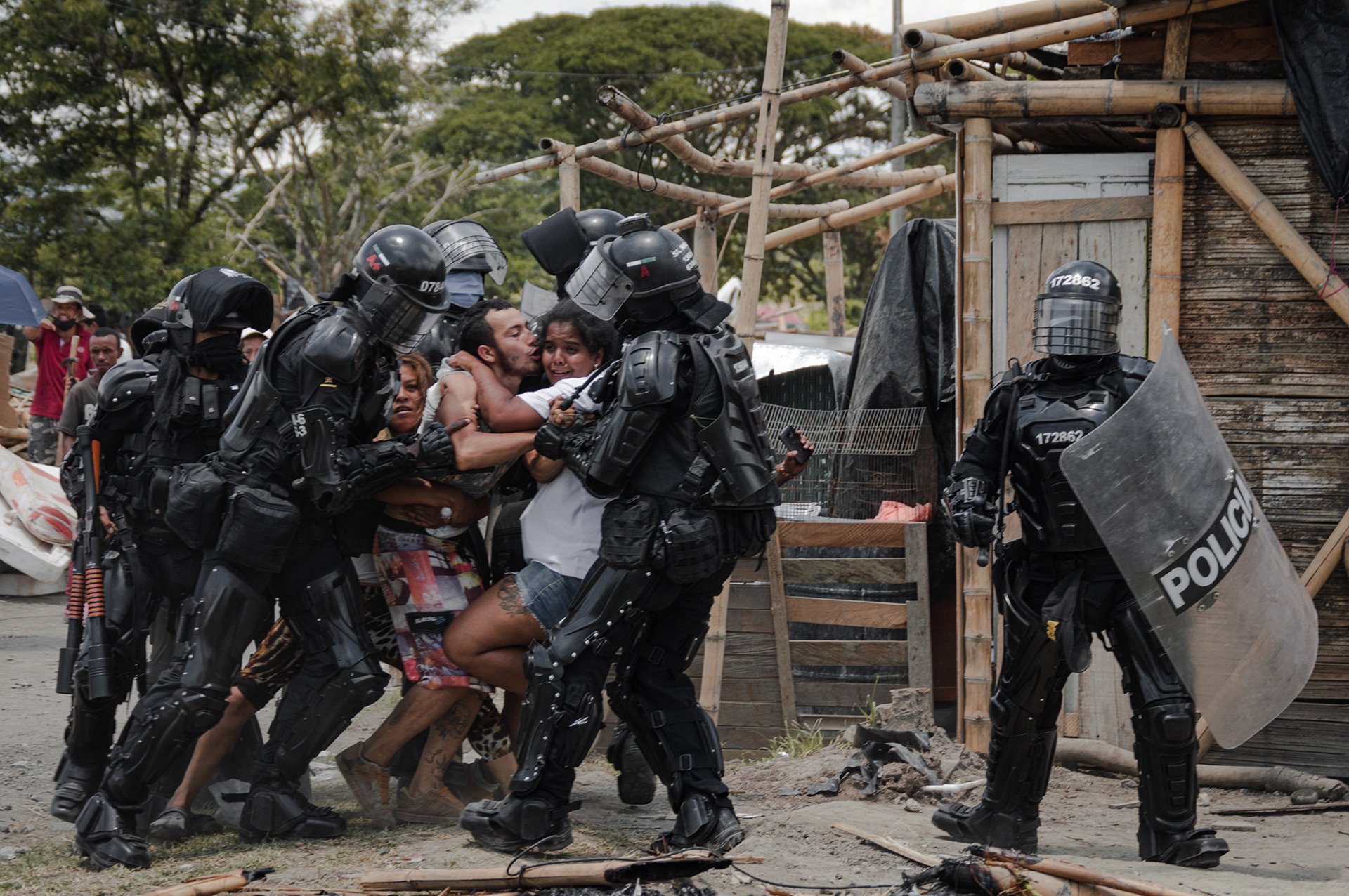 <p>Police agents arrest a man while his wife and family resist, during evictions of people from the San Isidro settlement, in Puerto Caldas, Risaralda, Colombia.</p>
