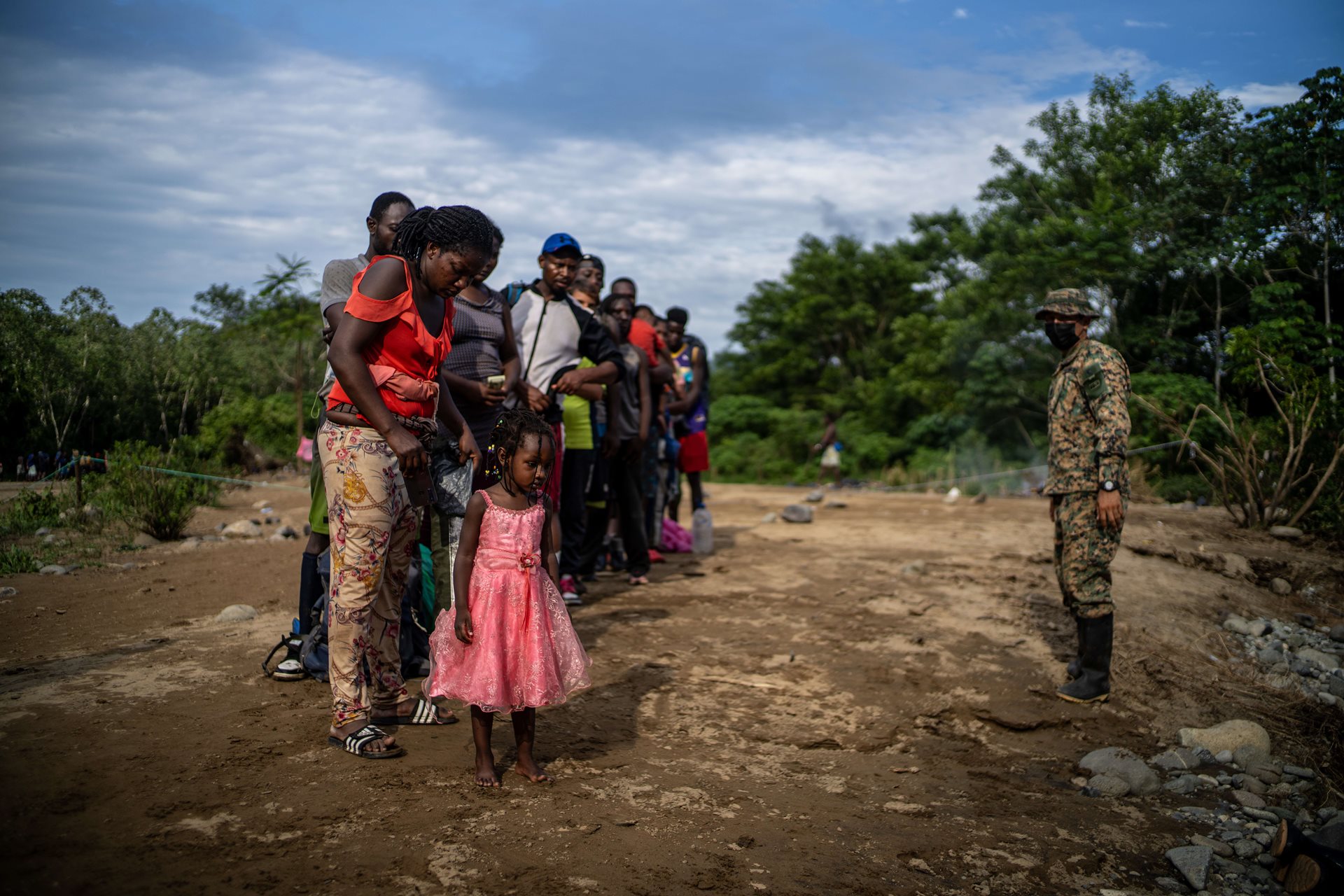 A member of the Panama National Border Service instructs a group of Haitian migrants who have just arrived in Quiebra Venado, the first indigenous community on the Panama side of the Darién Gap, after days of crossing the jungle. Darién Gap, Panama.