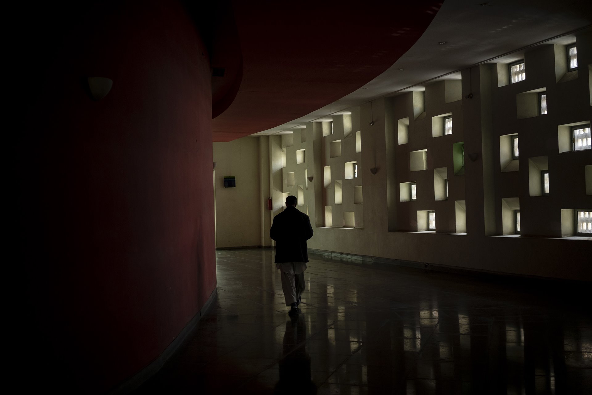 <p>A staff member walks through empty hallways at the Ariana Cinema in Kabul, Afghanistan. Even though the Taliban closed the government-owned cinema a few months earlier, the staff still arrive for work daily, in the hope they will eventually be paid.</p>
